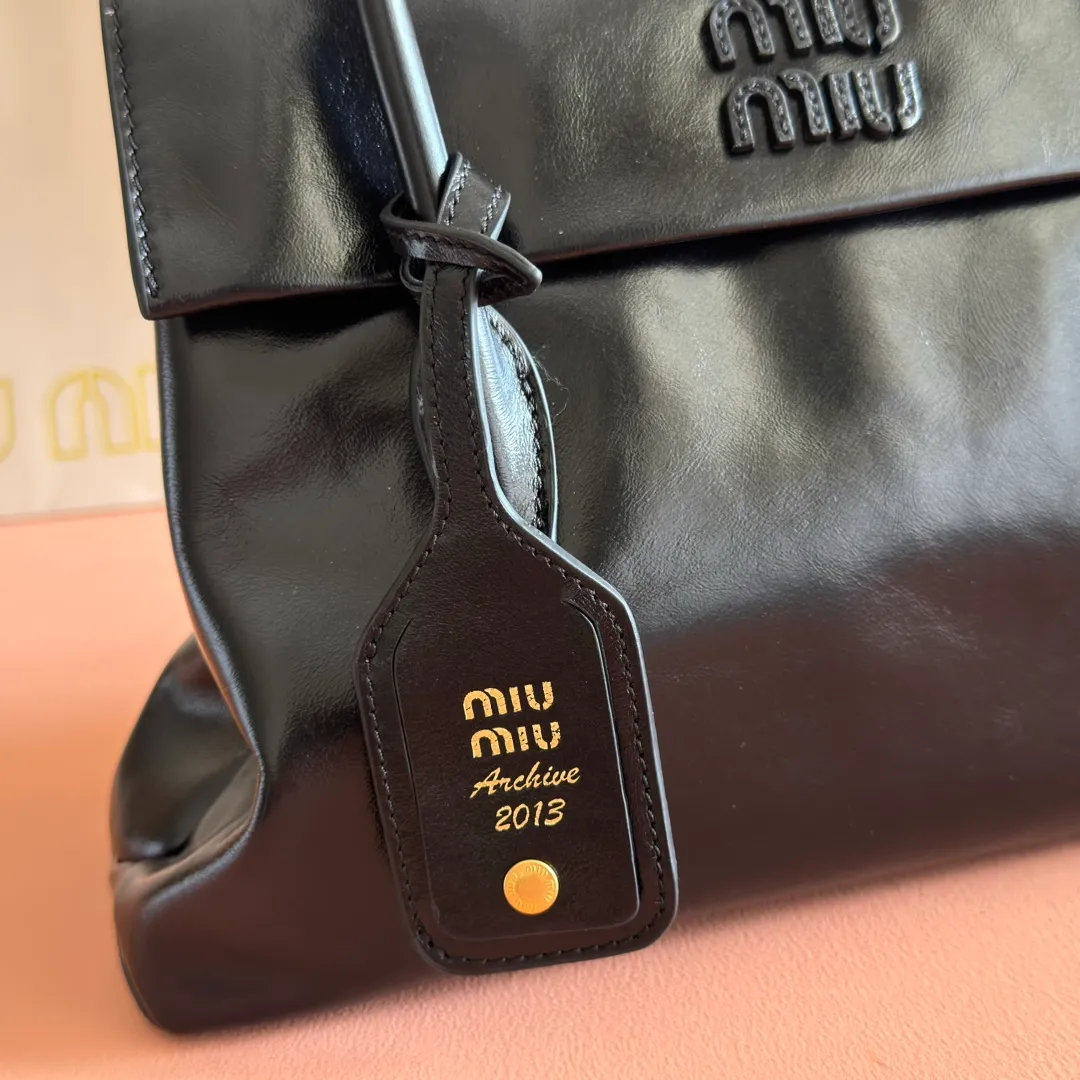 p1700💋💋💋【Configuring full counter package】Vintage cow leather Solitaire medium handbag: 5BA302 Structured lines and exquisite details define this handbag, inspired by MiuMiu's 2006 archives. An elegant style that combines classic and experimental is enhanced by the iconic logo on the front and a shiny finish. ·With handle ●With removable decoration. Comes with sliding and removable shoulder strap. Minimum length: 110 cm - Maximum length: 120 cm - Minimum drop: 50 cm - Maximum drop: 55 cm · Front and back pockets · Gold hardware · Zippered pockets and patch pockets ● Lettering logo on the front Width: 28 cm, Height: 19.5 cm, Length: 11 cm