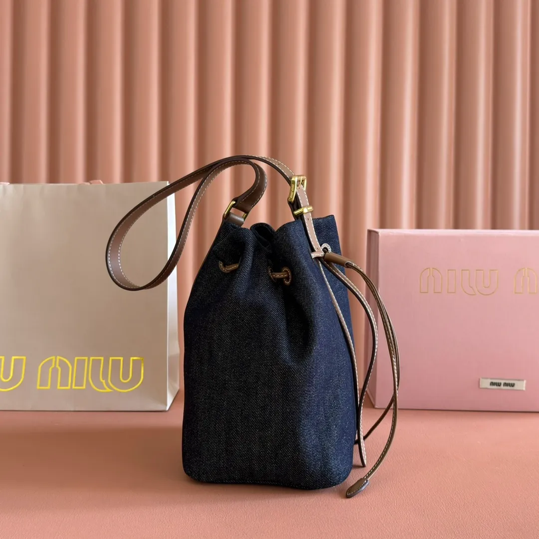 p1300💋💋💋【Full set of packaging at the counter】5BE089 Canvas Bucket Bag This canvas and leather bucket bag from Miu family is intertwined with contrasting materials and colors, highlighting its unique design features. The letter logo adds a unique personality to the design of this bag. Adjustable leather handles Gold-plated hardware Leather letter logo on front Leather drawstring closure Linen fabric lining Model: 5BE090 Dimensions: Height 16cm Width 22.5cm Length 14cm