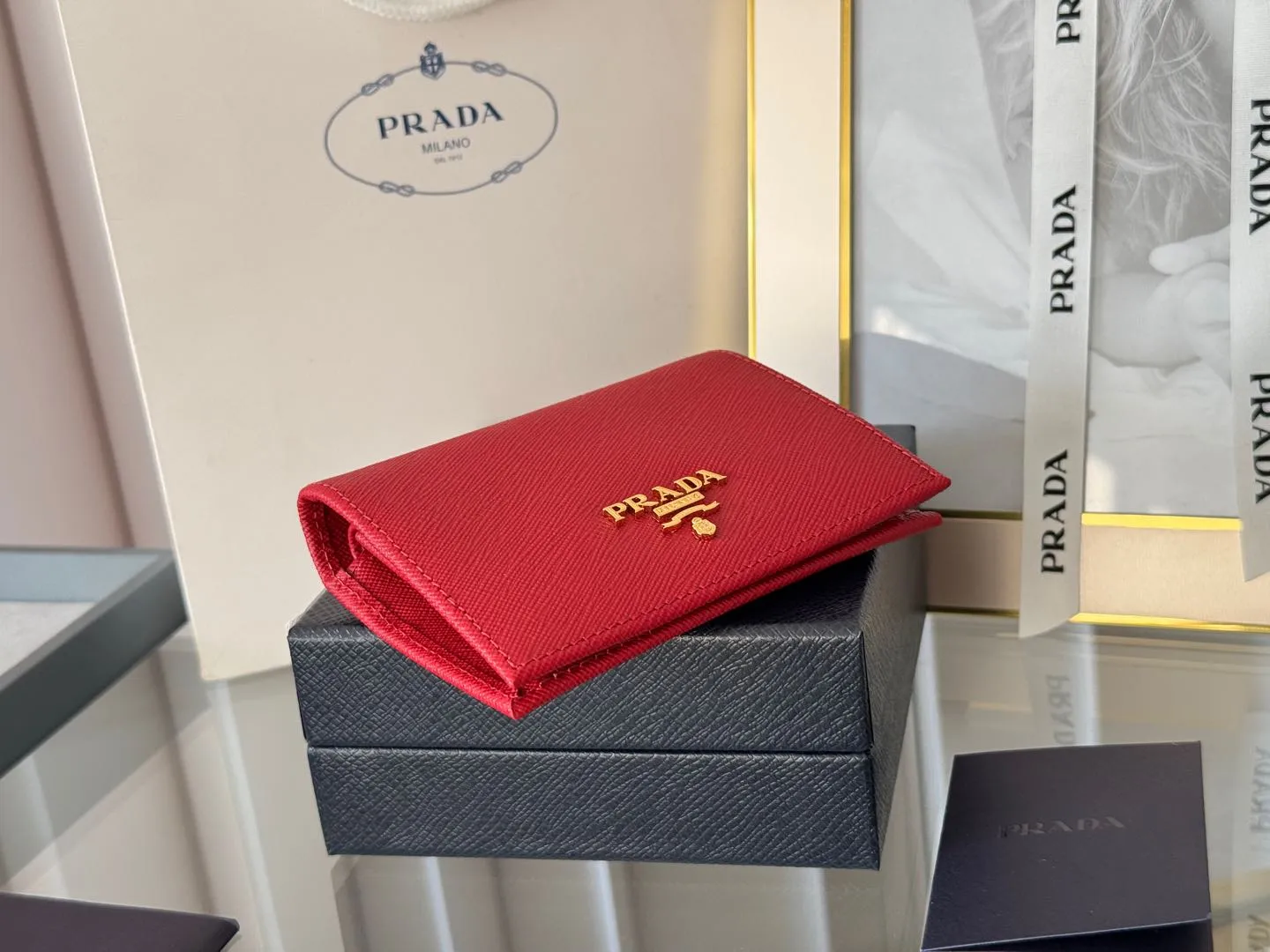 Prada women's two-fold short clip, with coin pocket and coin pocket. Model 1M0204, cross-grain cowhide. Size: 11.2x9.5cm. Simple and practical to enhance personal taste.