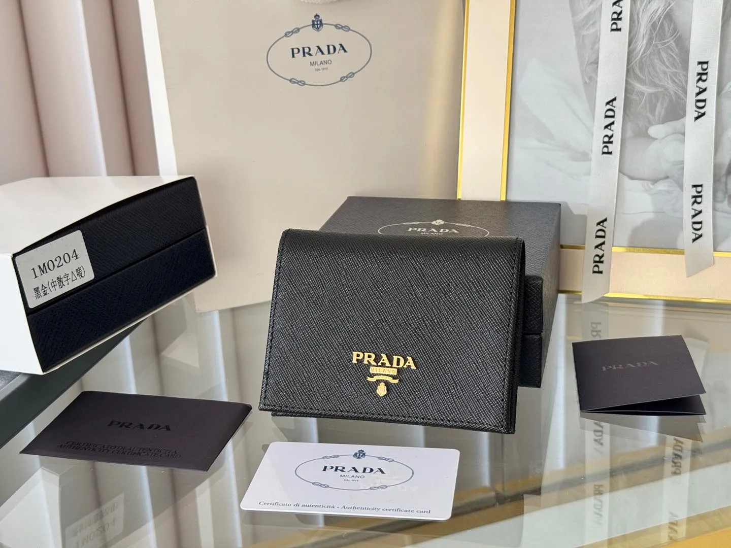 Prada women's two-fold short clip, with coin pocket and coin pocket. Model 1M0204, cross-grain cowhide. Size: 11.2x9.5cm. Simple and practical to enhance personal taste.