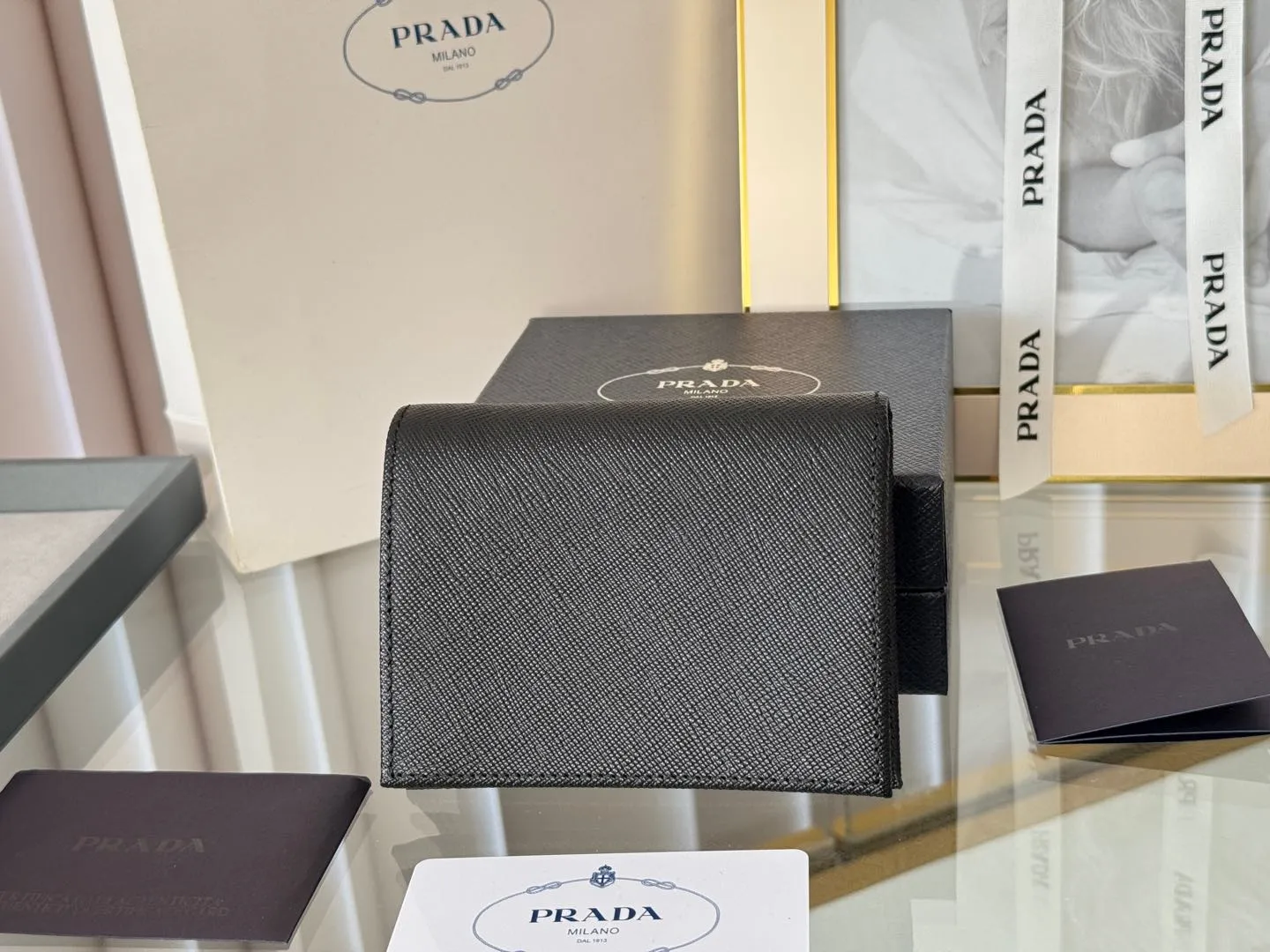 Prada women's two-fold short clip, with coin pocket and coin pocket. Model 1M0204, cross-grain cowhide. Size: 11.2x9.5cm. Simple and practical to enhance personal taste.