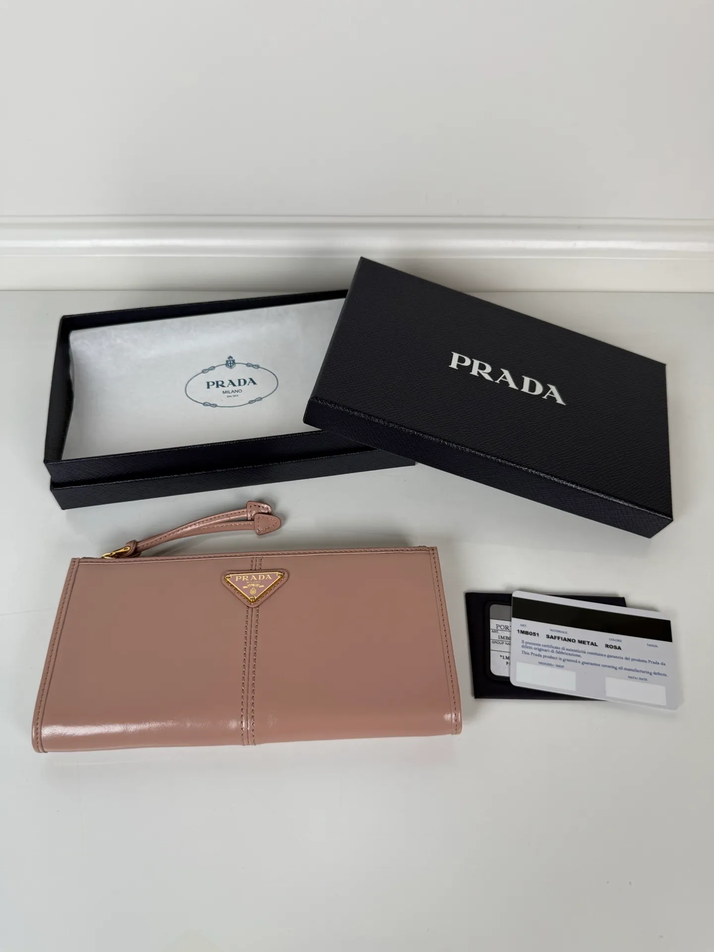 💰520, P Home ➡️Unisex pouch bag, this pouch is simple and exquisite, made of imported wax leather, with triangular metal logo and zipper closure. Model: 1MB051, size 20cm*10cm, 2 card slots, 1 leather lining