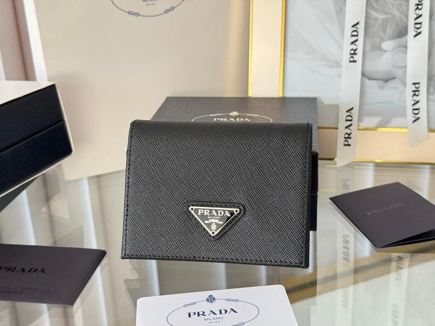 Prada women's two-fold short clip, with coin pocket and coin pocket. Model 1M0204, cross-grain cowhide. Size: 11.2x9.5cm. Simple and practical to enhance personal taste.