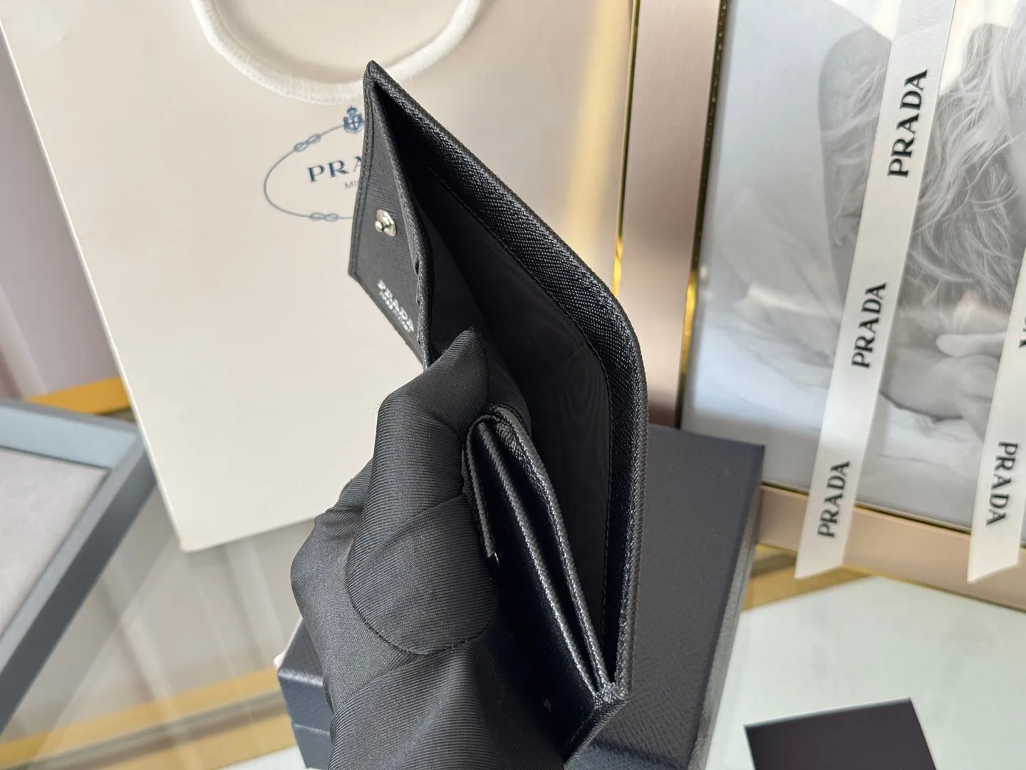 Prada women's two-fold short clip, with coin pocket and coin pocket. Model 1M0204, cross-grain cowhide. Size: 11.2x9.5cm. Simple and practical to enhance personal taste.