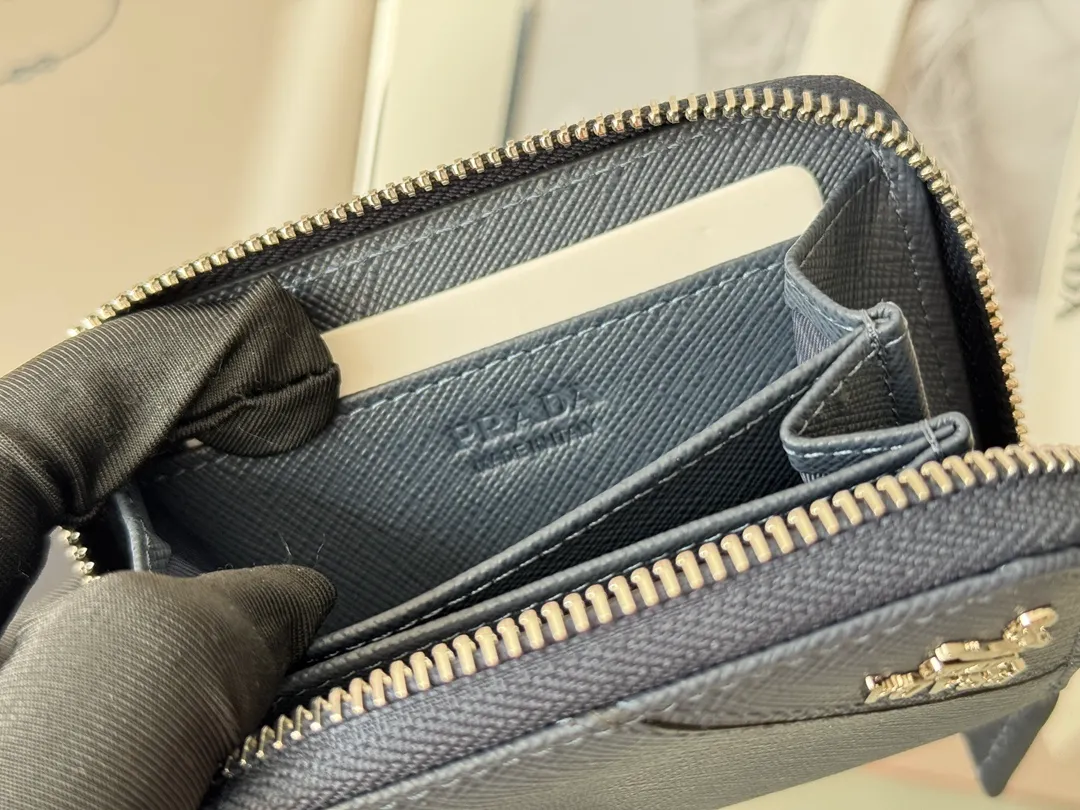 Prada Cross Pattern Unisex Card Holder Zipper Bag Model: 2MM358 Size: 10*8cm Original quality Color details are as shown in the picture, exclusive real shot Can be placed in the bag or held in hand Small and cute leather goods, made of cross pattern cowhide Classic and practical zipper design, with pleated card slots inside for easy classification and storage. It is perfect for going out alone with your mobile phone in summer or putting it in a small bag. It is your best choice.