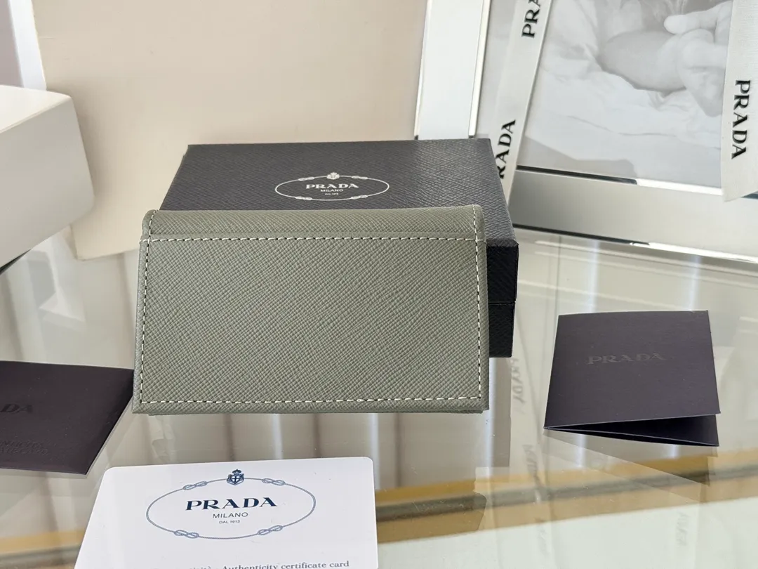 Prada classic card holder, model 1MC122, made of cross-grain cowhide, size 6.5×2.5×11cm, adopts snap button opening and closing design, and has two slots for cards or receipts. This exquisite card holder is small and convenient, with sufficient capacity. It can be placed in the bag for easy storage. It can also be used to make separate items when going out every day. Hot 🔥Hot-selling item, taken in kind, what you see is what you get