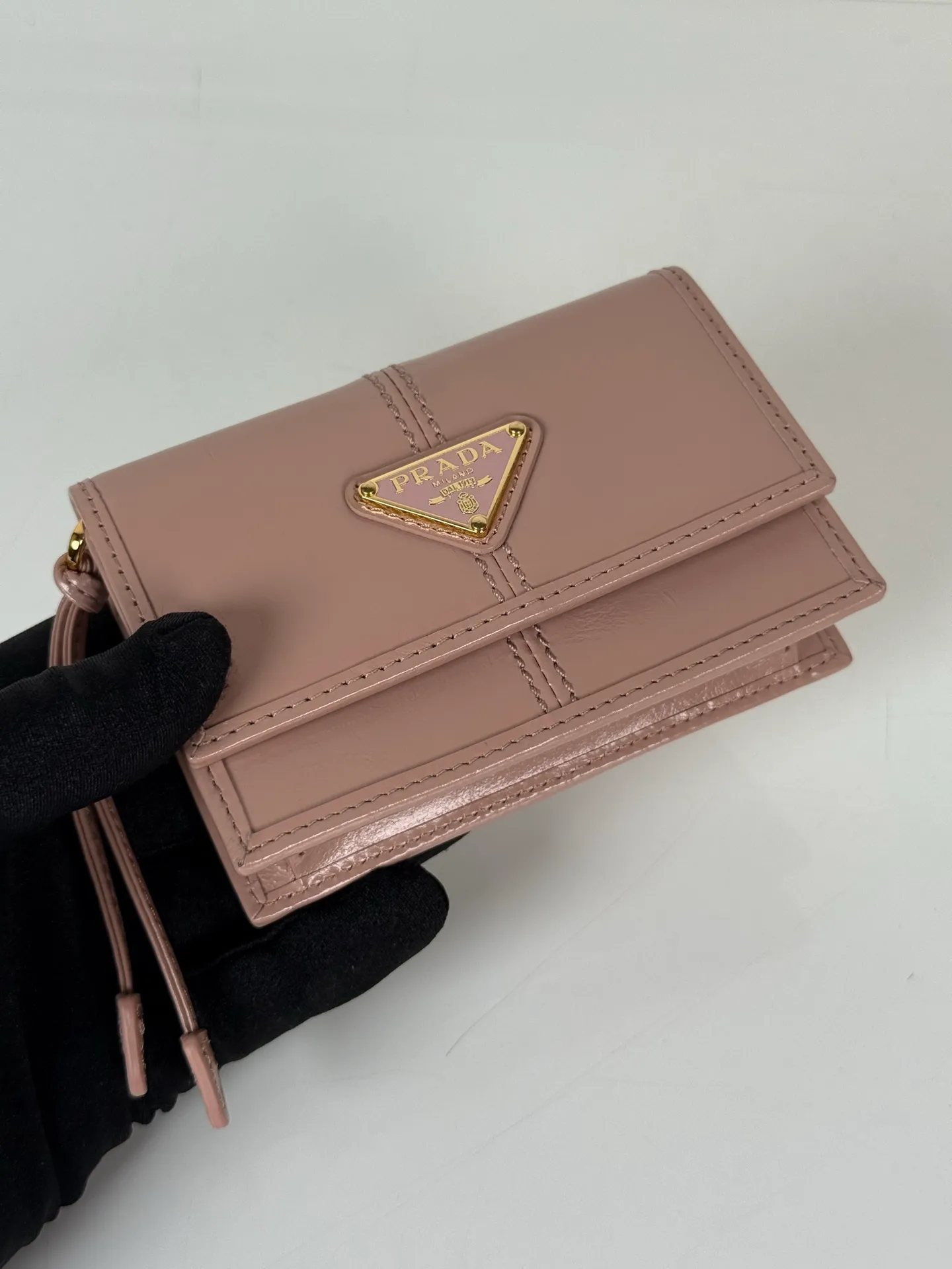💰900; P Home ➡️Multifunctional mini backpack for women, model 1MR034, flip-top card holder with detachable Saffiano leather shoulder strap, metal triangular micro-mark decorating the front, size 11.5 x8 x2.5cm, two card slots inside, snap closure, in summer it is a mini backpack, in winter it can be turned into a small card holder by removing the shoulder strap, super practical and worth owning👍