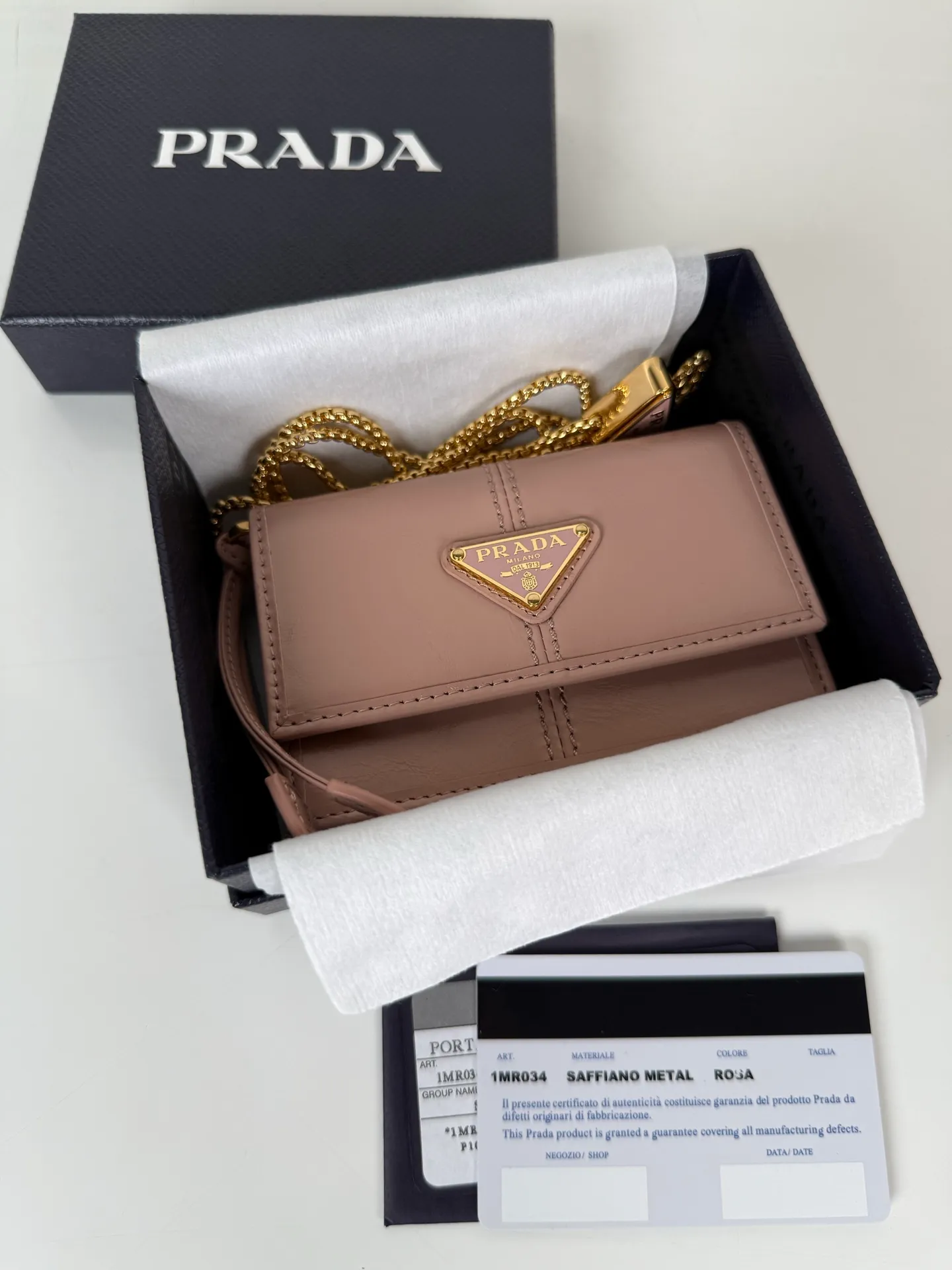 💰900; P Home ➡️Multifunctional mini backpack for women, model 1MR034, flip-top card holder with detachable Saffiano leather shoulder strap, metal triangular micro-mark decorating the front, size 11.5 x8 x2.5cm, two card slots inside, snap closure, in summer it is a mini backpack, in winter it can be turned into a small card holder by removing the shoulder strap, super practical and worth owning👍