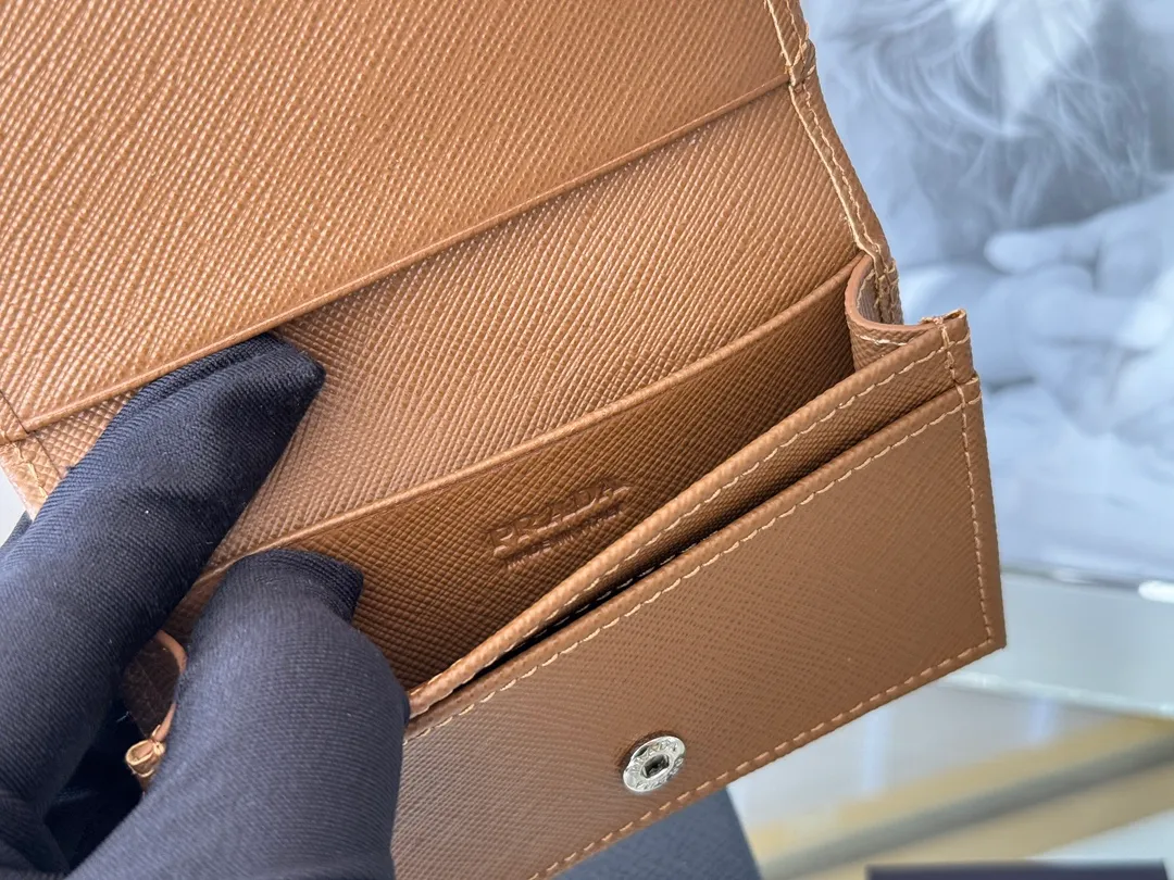 Prada classic card holder, model 1MC122, made of cross-grain cowhide, size 6.5×2.5×11cm, adopts snap button opening and closing design, and has two slots for cards or receipts. This exquisite card holder is small and convenient, with sufficient capacity. It can be placed in the bag for easy storage. It can also be used to make separate items when going out every day. Hot 🔥Hot-selling item, taken in kind, what you see is what you get