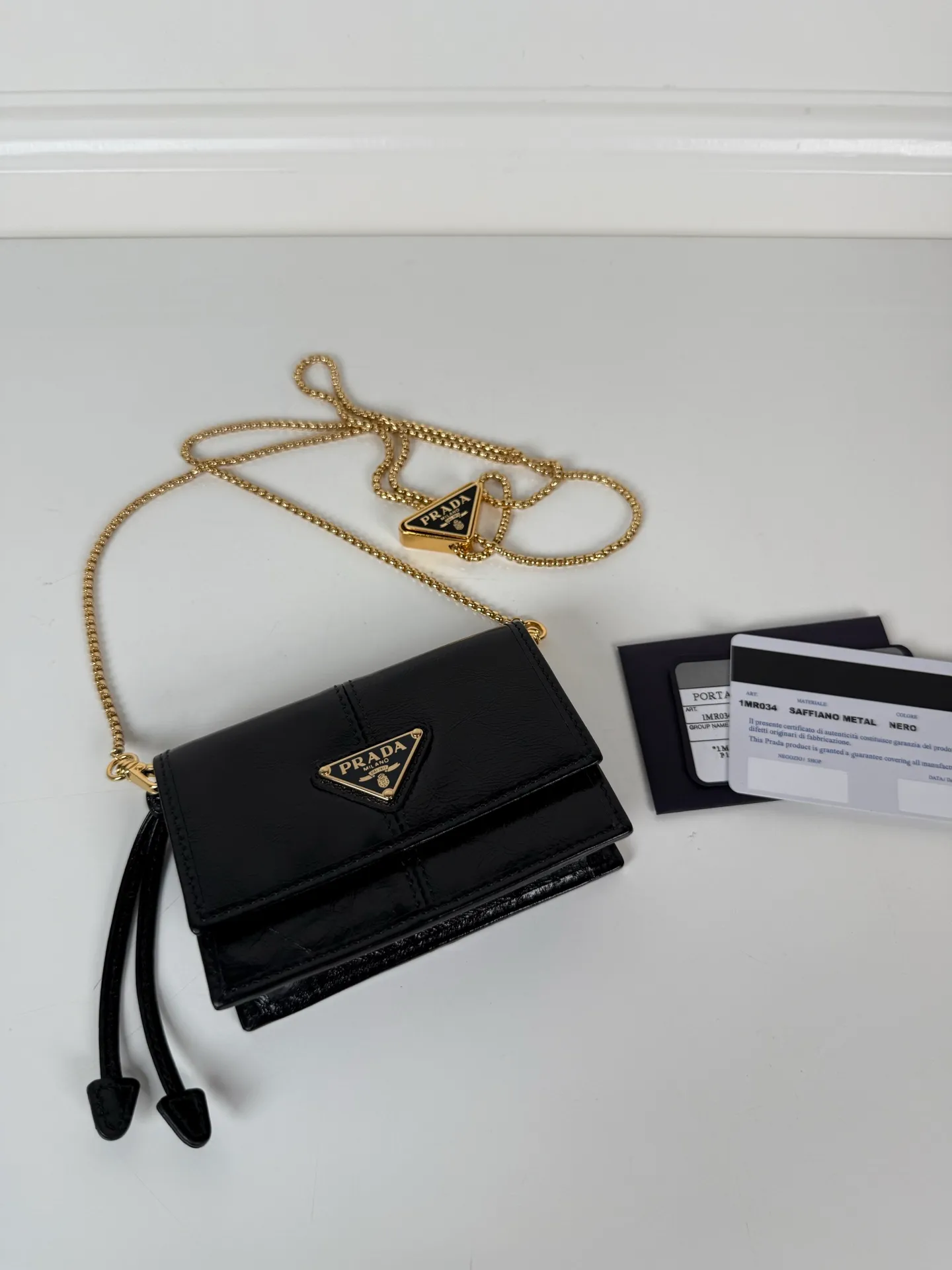 P Home➡️Ladies multifunctional mini backpack, model 1MR034, flip-top card holder with detachable Saffiano leather shoulder strap, metal triangular micro logo decorating the front, size 11.5 x8 x2.5cm, two card slots inside, snap closure, it is a mini backpack in summer, and it can be transformed into a small card holder by removing the shoulder strap in winter. It is super practical and worth having👍