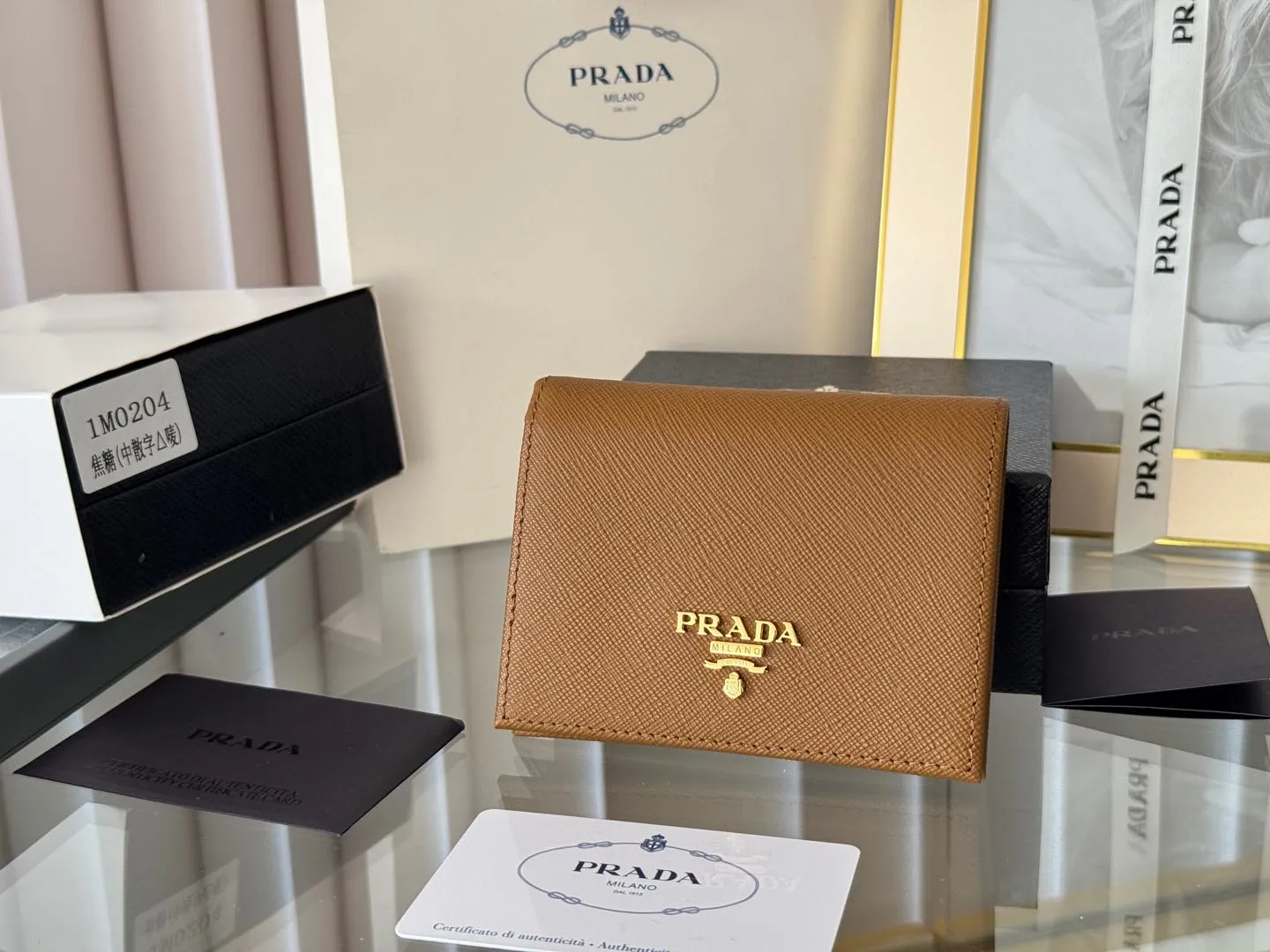Prada women's two-fold short clip, with coin pocket and coin pocket. Model 1M0204, cross-grain cowhide. Size: 11.2x9.5cm. Simple and practical to enhance personal taste.
