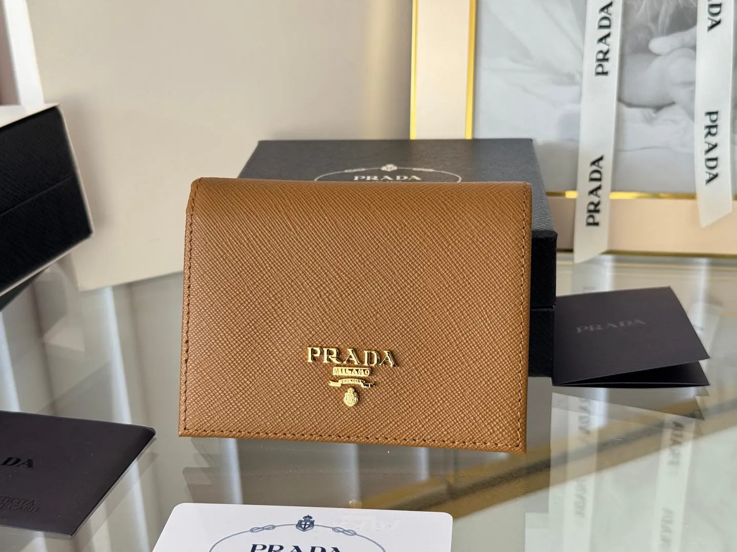 Prada women's two-fold short clip, with coin pocket and coin pocket. Model 1M0204, cross-grain cowhide. Size: 11.2x9.5cm. Simple and practical to enhance personal taste.