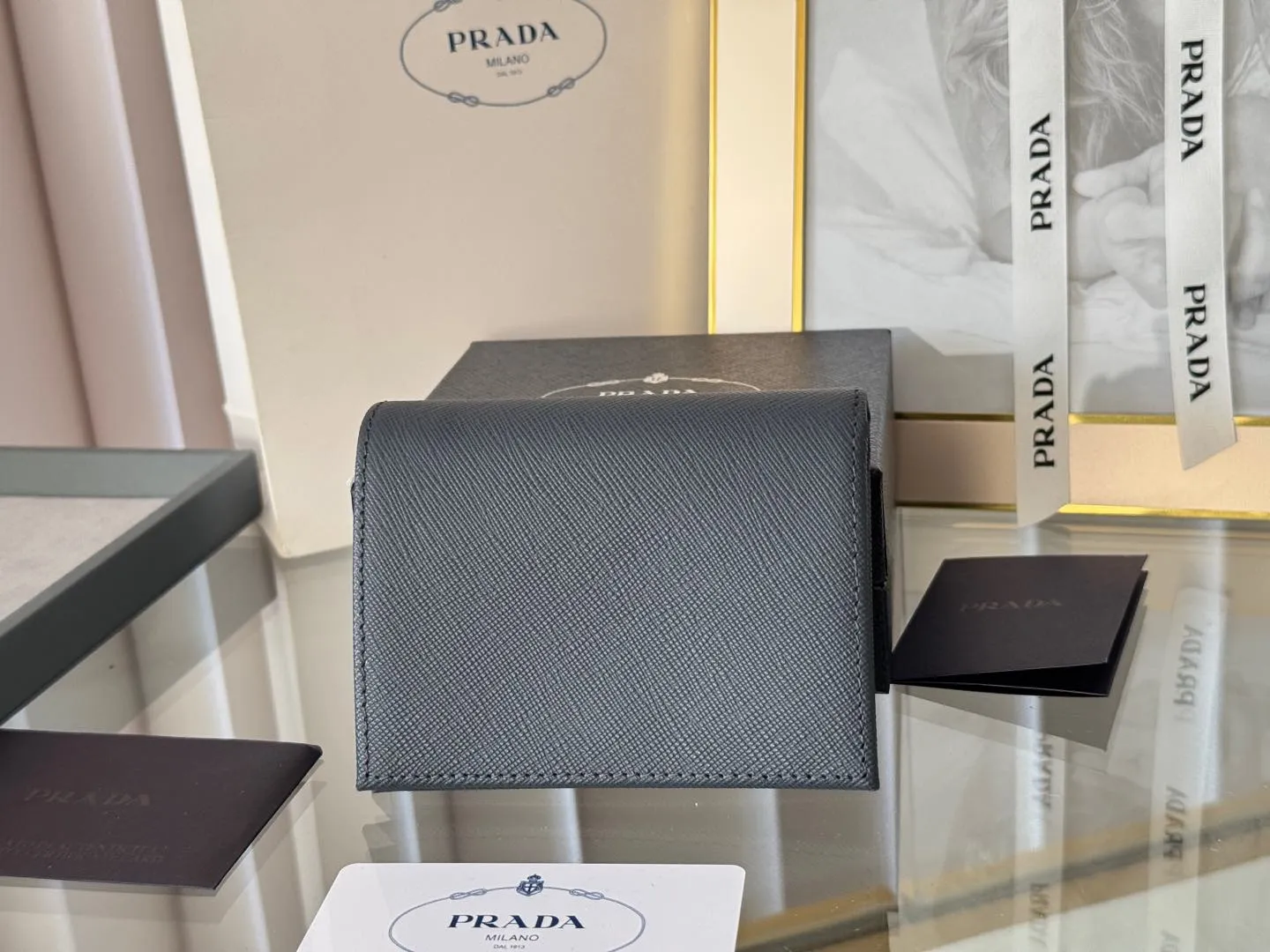 Prada women's two-fold short clip, with coin pocket and coin pocket. Model 1M0204, cross-grain cowhide. Size: 11.2x9.5cm. Simple and practical to enhance personal taste.