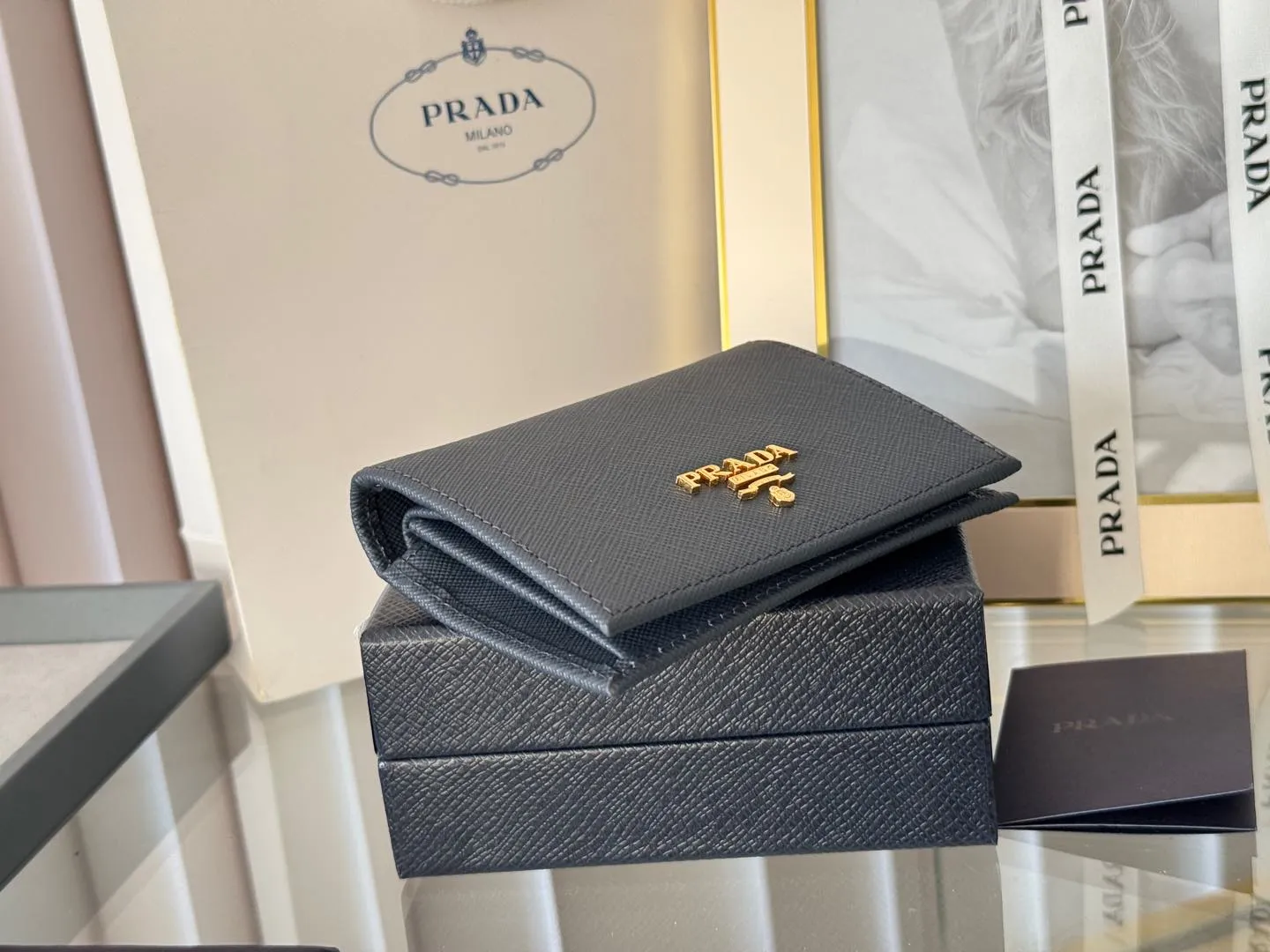 Prada women's two-fold short clip, with coin pocket and coin pocket. Model 1M0204, cross-grain cowhide. Size: 11.2x9.5cm. Simple and practical to enhance personal taste.