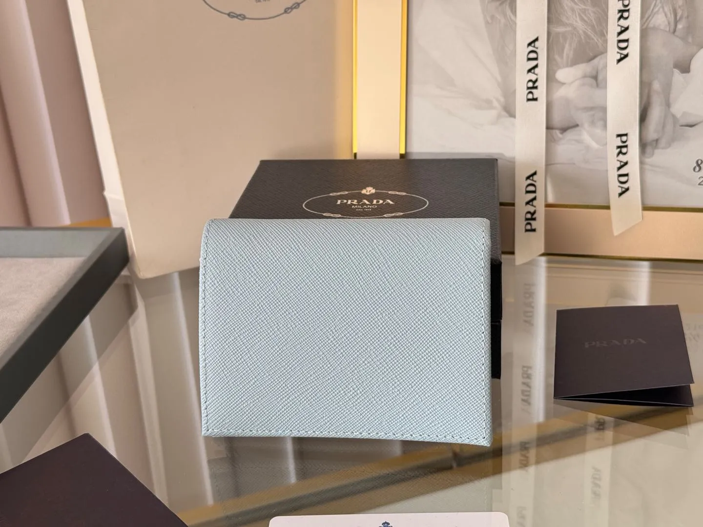 Prada women's two-fold short clip, with coin pocket and coin pocket. Model 1M0204, cross-grain cowhide. Size: 11.2x9.5cm. Simple and practical to enhance personal taste.