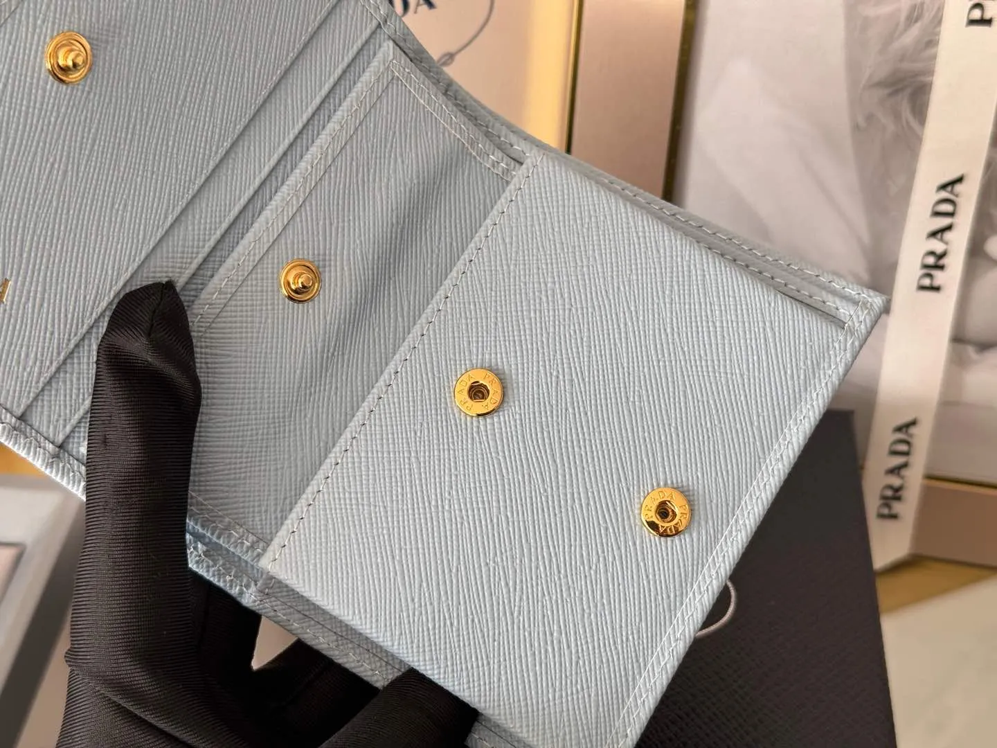 Prada women's two-fold short clip, with coin pocket and coin pocket. Model 1M0204, cross-grain cowhide. Size: 11.2x9.5cm. Simple and practical to enhance personal taste.