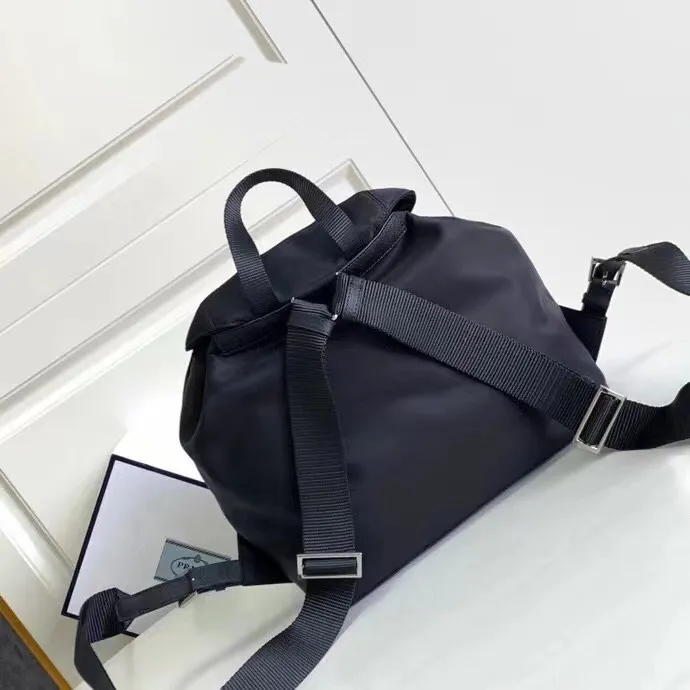 P640¥PR@DA 1BZ811 Nylon backpack is the most classic, best-selling and most versatile backpack of the P family. It is the first nylon bag designed by the chief founder himself. It is lightweight, rainproof, has a moderate capacity and is suitable for travel. It is matched with imported parachute fabric - waterproof and sunproof. Triangular enamel logo on the front, cross pattern cowhide trim. The overall style is fashionable and casual, yet stable and dignified. It has a large capacity to hold a kettle, iPad, mobile phone, books and documents. The drawstring inner bag + the two front zipper outer pockets meet the exquisite storage needs [Celebration]: 32*30*15cm black
