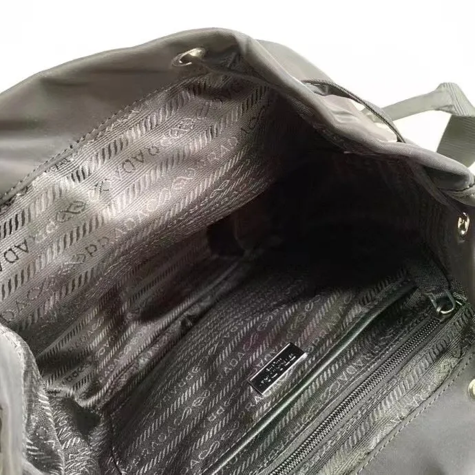 P640¥PR@DA 1BZ811 Nylon backpack is the most classic, best-selling and most versatile backpack of the P family. It is the first nylon bag designed by the chief founder himself. It is lightweight, rainproof, has a moderate capacity and is suitable for travel. It is matched with imported parachute fabric - waterproof and sunproof. Triangular enamel logo on the front, cross pattern cowhide trim. The overall style is fashionable and casual, yet stable and dignified. It has a large capacity to hold a kettle, iPad, mobile phone, books and documents. The drawstring inner bag + the two front zipper outer pockets meet the exquisite storage needs [Celebration]: 32*30*15cm black