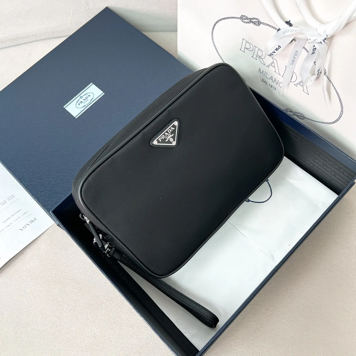 💰700, 2NE007 Men's nylon clutch, imported parachute fabric, triangular enamel logo on the front, very beautiful and elegant. Nylon has always been an area that cannot be surpassed by other brands. The fabric texture is very soft and comfortable, fashionable, lightweight and practical. It is very fashionable to match casually. This capacity is very large and can be used by both men and women. Size: 24*16*7cm black