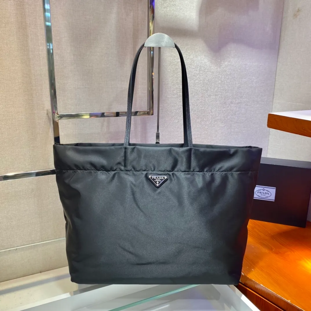 💰920🎉New Tote Bag🎉1BG107🎉This medium tote bag is made of innovative recycled nylon fabric with a simple and stylish design. The body of the bag is equipped with exquisite Saffiano leather handles and is decorated with the iconic enameled triangle metal logo to convey the brand message. Large space capacity 👍 Very practical 👍 Stylish and simple, it is also a shopping bag that will never go out of style. If you like babies, hurry up and get it 😘😘 Length 40x Height 34x Bottom 16cm