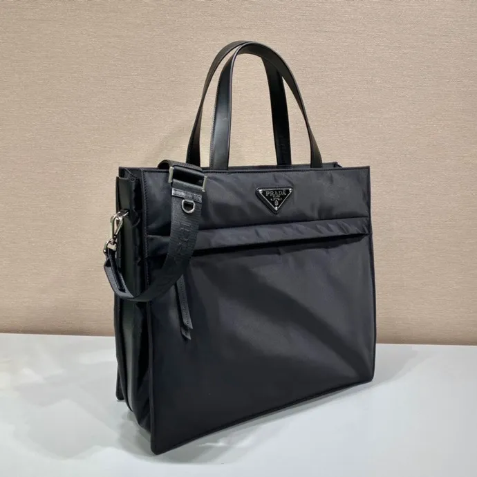 💰1460🎉Upgraded Tote Bag🎉2VG076 This tote bag has a compact square design and is decorated with leather details. The iconic enamel triangle logo on the front highlights the brand's style. Equipped with a detachable long shoulder strap, the bag body is made of Re-Nylon regenerated nylon, which can be called the evolution of P's signature fabric selection. Lightweight and stylish, suitable for both men and women, get it now🎉🎉 Length 38x Height 36x Bottom 14cm