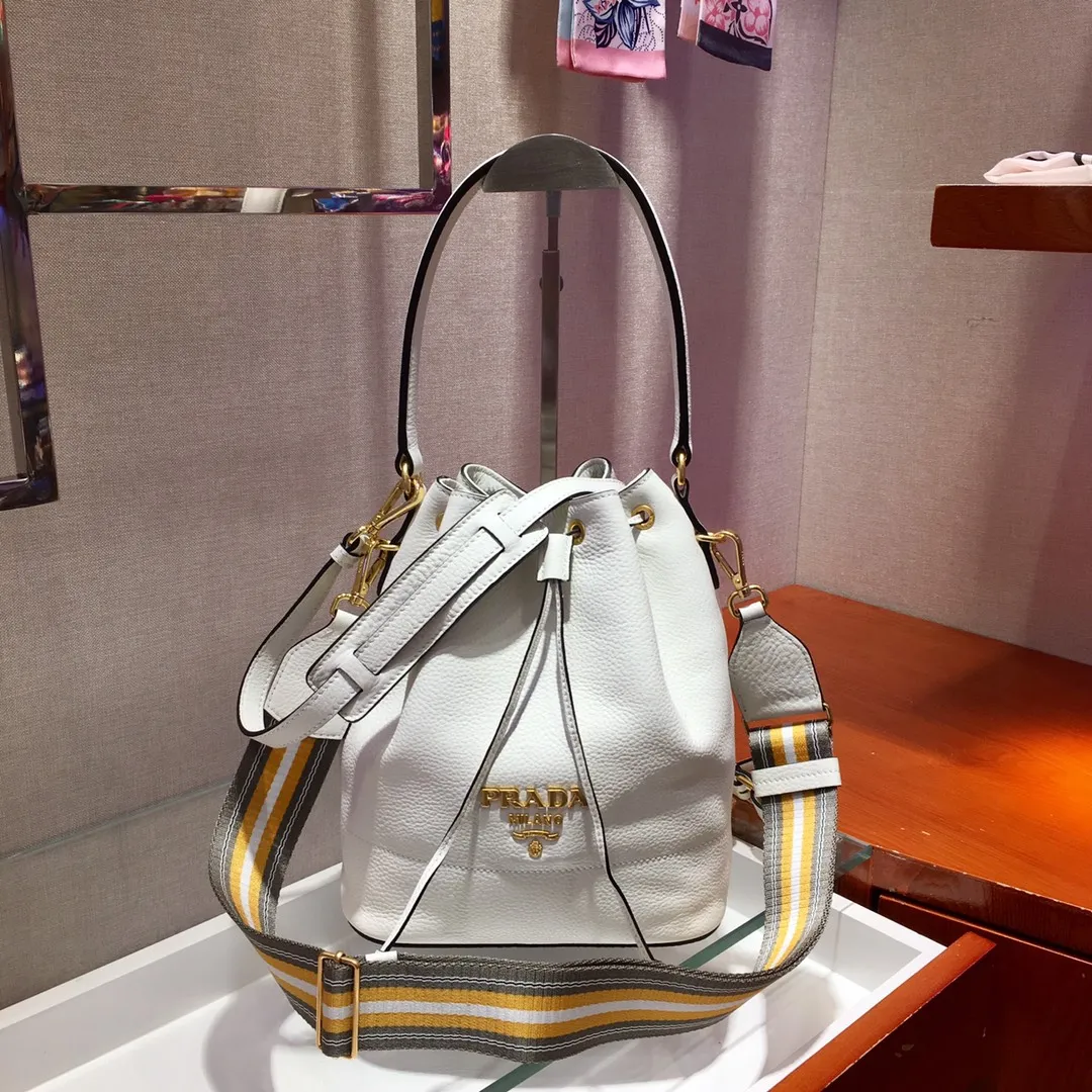 💰1660, P family has another popular bucket bag👏🏻👏🏻1BE018, the latest/most popular bucket bag🤙🤙Made of imported calfskin deerskin grain material, leather handle/2 replacement shoulder straps👏🏻👏🏻Detachable and adjustable colorful fabric shoulder straps, equipped with leather shoulder pads, metal lettering logo Decorated with a leather drawstring on the top, logo lining, there is a leather pocket inside, a large capacity and beautiful style🙋🏻🙋🏻, length 21x height 25x bottom 15cm.🤙🤙🤙💰💰💰