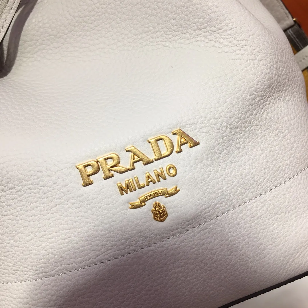 💰1660, P family has another popular bucket bag👏🏻👏🏻1BE018, the latest/most popular bucket bag🤙🤙Made of imported calfskin deerskin grain material, leather handle/2 replacement shoulder straps👏🏻👏🏻Detachable and adjustable colorful fabric shoulder straps, equipped with leather shoulder pads, metal lettering logo Decorated with a leather drawstring on the top, logo lining, there is a leather pocket inside, a large capacity and beautiful style🙋🏻🙋🏻, length 21x height 25x bottom 15cm.🤙🤙🤙💰💰💰