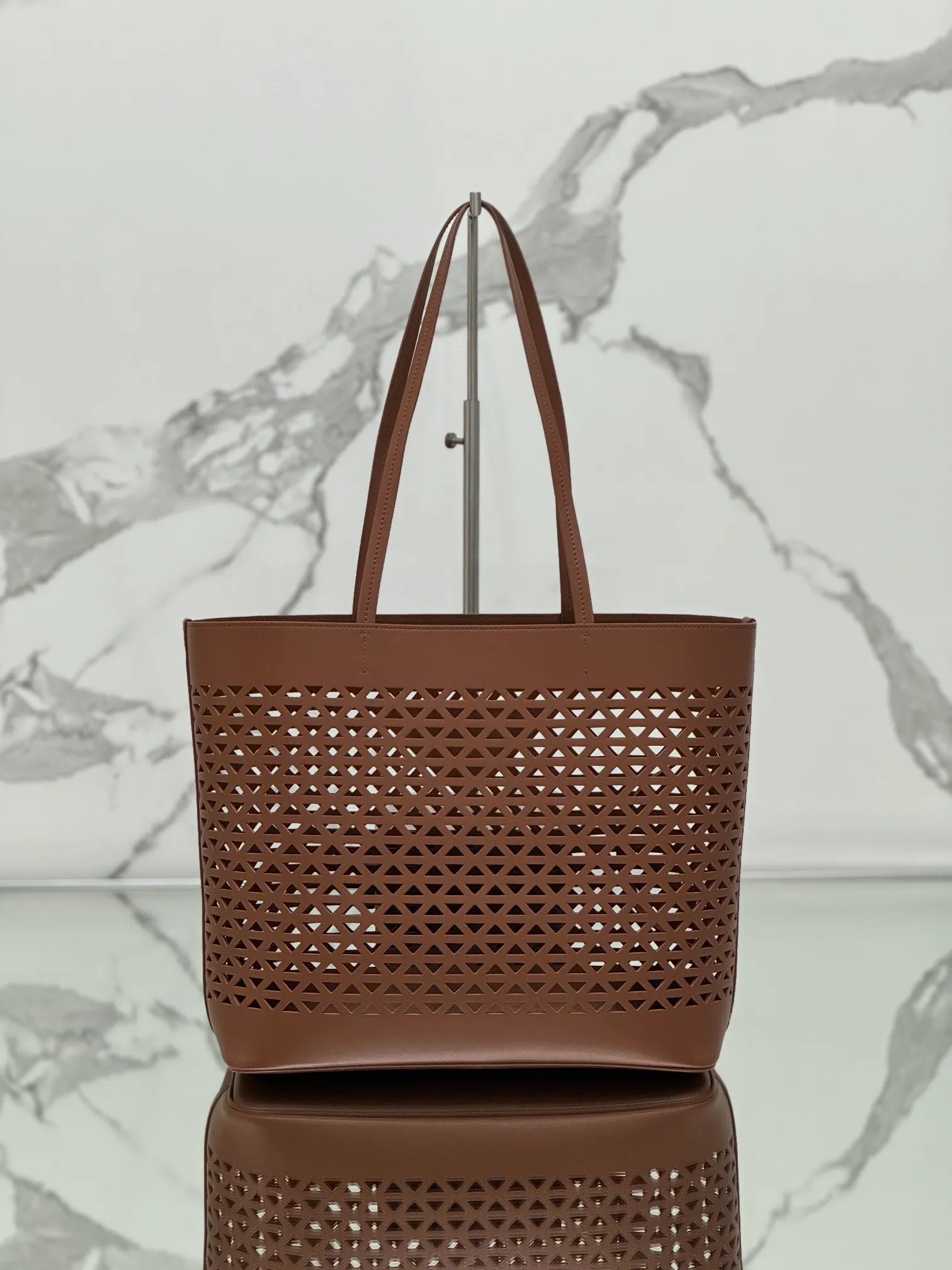💰1800🌟Hollow Tote Shopping Bag This bag is made of hollowed-out imported calf leather and has a fashionable design. The bag is equipped with exquisite leather handles to convey the brand message. It has a large space and is very practical. It is a shopping bag that will turn heads every time and comes with a small coin purse. Size: 32×30×13cm Style number: 1BG503