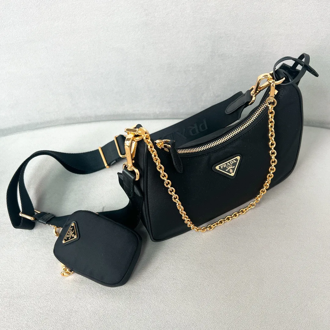 💰1000 [The latest black gold chain⛓️] Prad 2005 nylon three-in-one 1BH204, made of Re-Nylon regenerated nylon material, the design is inspired by the iconic mini Hobo handbag, the Saffiano leather trim design is unique, and the shoulder strap is equipped with a detachable pouch to create a variety of looks. Detachable chain handle, detachable and adjustable logo-printed woven nylon shoulder strap, detachable nylon zippered pouch with ReEdition keychain, metal accessories, enameled metal triangle logo on the front, zipper closure, upgraded details, matching counter, market exclusive! Size: 22X18X6cm