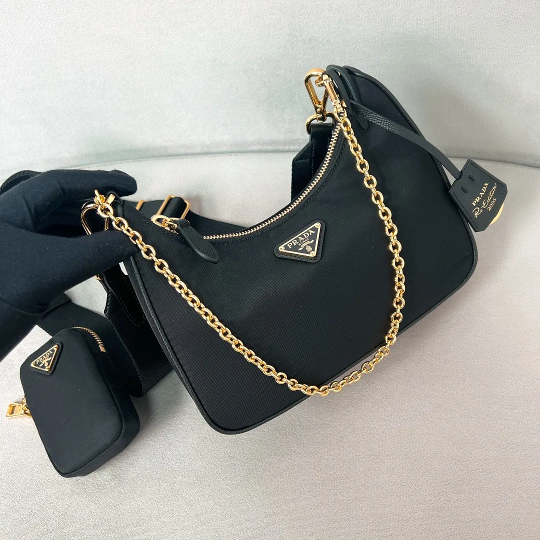 💰1000 [The latest black gold chain⛓️] Prad 2005 nylon three-in-one 1BH204, made of Re-Nylon regenerated nylon material, the design is inspired by the iconic mini Hobo handbag, the Saffiano leather trim design is unique, and the shoulder strap is equipped with a detachable pouch to create a variety of looks. Detachable chain handle, detachable and adjustable logo-printed woven nylon shoulder strap, detachable nylon zippered pouch with ReEdition keychain, metal accessories, enameled metal triangle logo on the front, zipper closure, upgraded details, matching counter, market exclusive! Size: 22X18X6cm