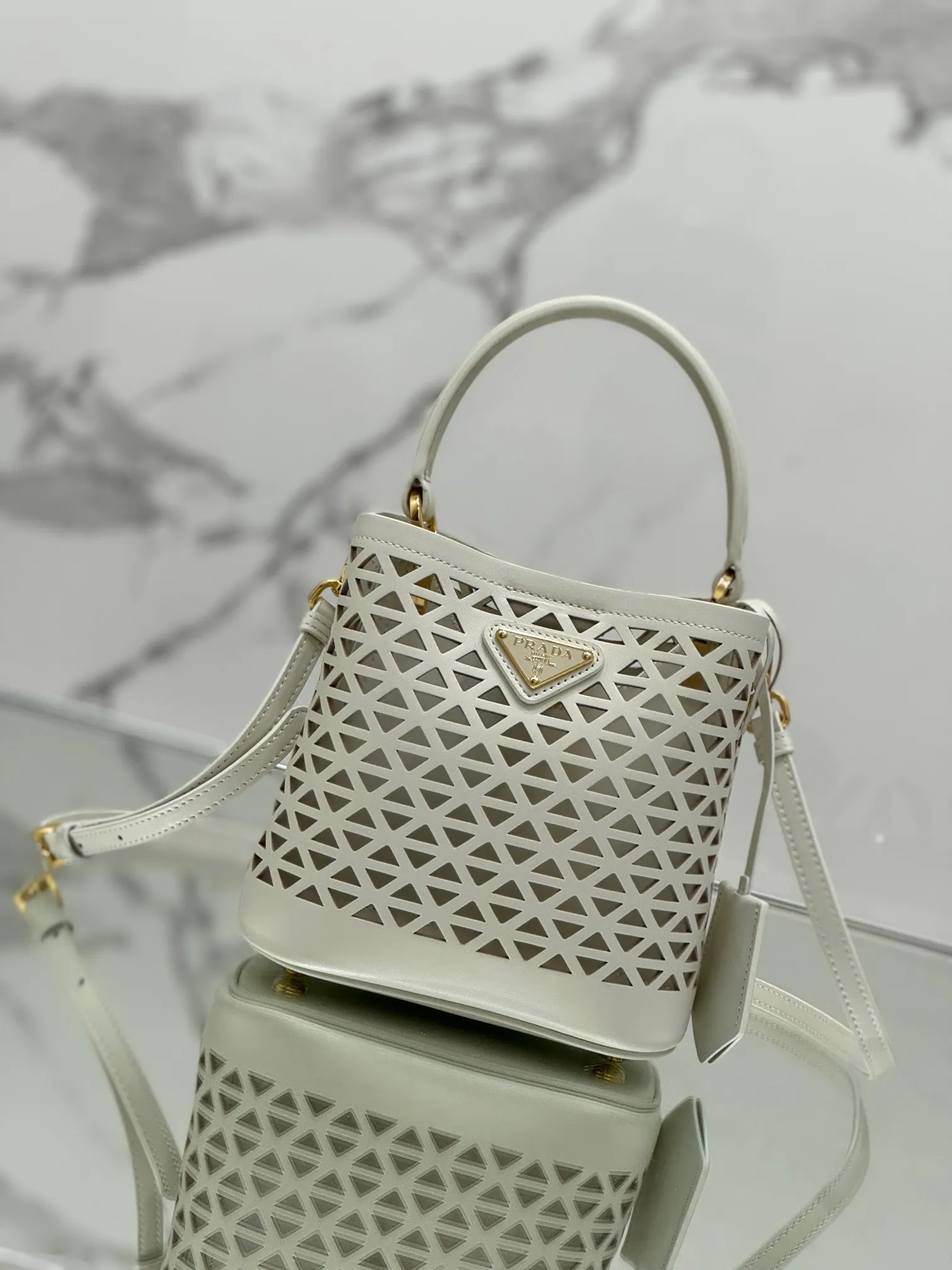 💰1640🌟Hollowout🐮Leather bucket bag The popular "elf" Saffiano perforated calfskin gives this P bucket bag a unique charm. The shape is not too soft and lacks spirit, nor is it too dull and lacks texture. The cute mini size adds a sense of fashion. It can be carried in hand, shoulder or crossbody. It is a handbag that perfectly integrates classic heritage and the trend of the times. Size: 18×17×10.5 cm Style number: 1BA217