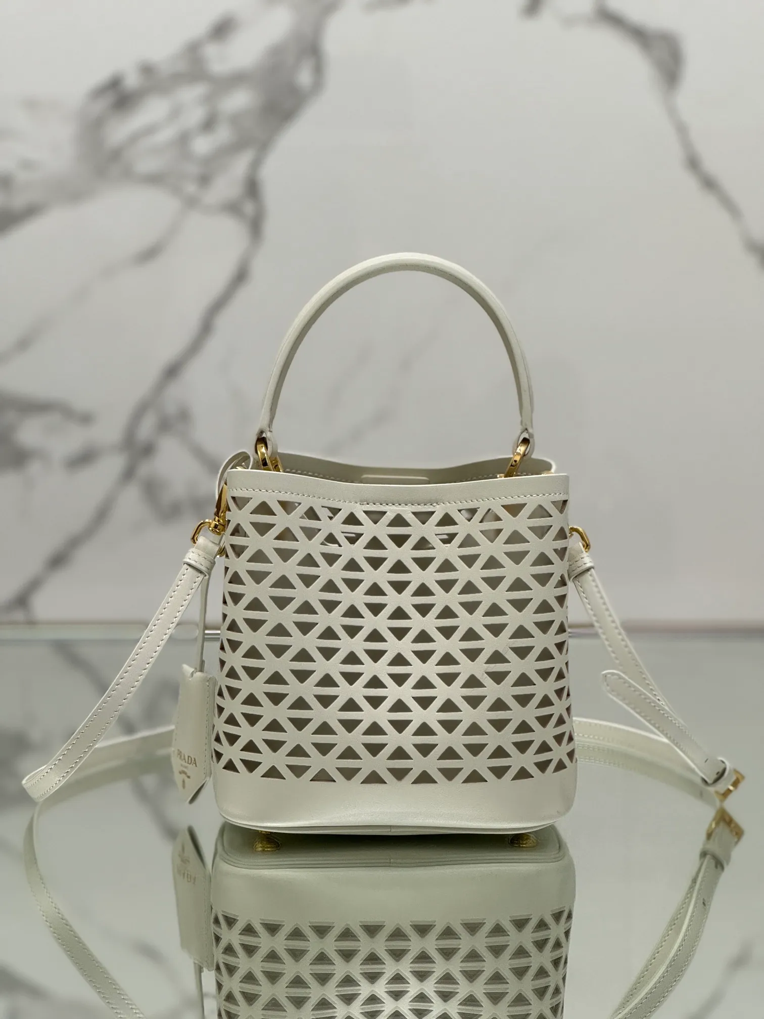 💰1640🌟Hollowout🐮Leather bucket bag The popular "elf" Saffiano perforated calfskin gives this P bucket bag a unique charm. The shape is not too soft and lacks spirit, nor is it too dull and lacks texture. The cute mini size adds a sense of fashion. It can be carried in hand, shoulder or crossbody. It is a handbag that perfectly integrates classic heritage and the trend of the times. Size: 18×17×10.5 cm Style number: 1BA217