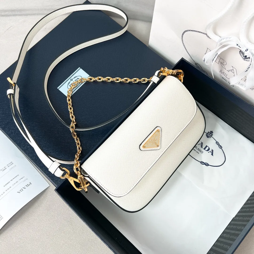 💰1360✨New product launch✨2024 spring and summer new series Saffiano shoulder bag 1BD356 is made of exquisite cross-grain cowhide and is equipped with the iconic triangle logo. It is equipped with a chain shoulder strap and a cross-body full leather shoulder strap. The shoulder strap is detachable and adjustable and can be carried under the armpit or on one shoulder. The overall style of the bag is simple and elegant. It combines fashion and retro style. The inner compartment capacity is also great. A new fashion trend-setter that combines retro fashion and practicality😘 Size 20.5*10.5*4 White