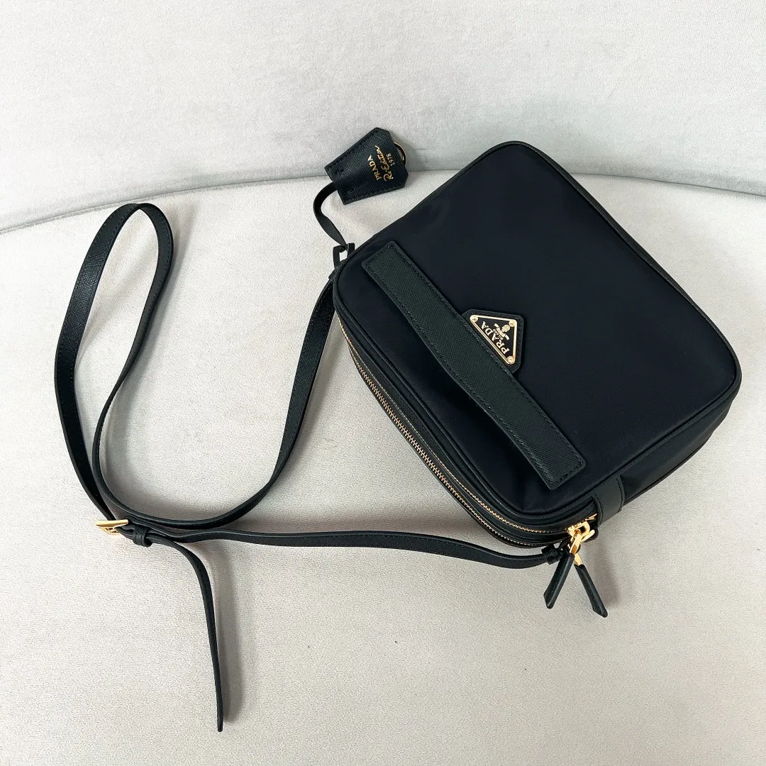 💰1160✨New product debut✨2024Summer new product Re-Edition1978 mini shoulder bag 1BH218 New design mini shoulder bag Made of imported nylon fabric➕Saffiano cowhide trim Elegant and simple bag design Classic logo gold triangle logo on the front Equipped with full leather adjustable long shoulder strap Double zipper closure Equipped with two space compartments➕zipper patch pocket and mobile phone patch pocket Meets exquisite storage needs, perfect details comparable to brick cabinets, super awesome 5🌟 size: 21*17*8cm black