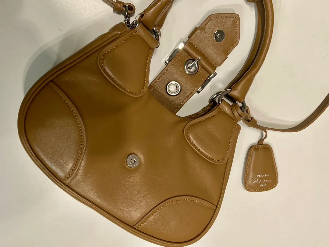 💰1700🎉New Moon handbag🎉1BA381 full lambskin🎉🎉 This Moon handbag is designed with imported lambskin, and the interior is also full sheepskin👏 It is equipped with a 100 cm detachable and adjustable leather long shoulder strap, which can be carried by hand or on the shoulder, a detachable leather keychain, and a triangle logo magnetic buckle/lace closure on the front. It is lightweight and practical, and the upper body effect is cool/fashionable. Another popular style that will never go out of style🎉🎉Hurry up and get it🎉 Length 22.5x Height 16x Bottom 7.5cm