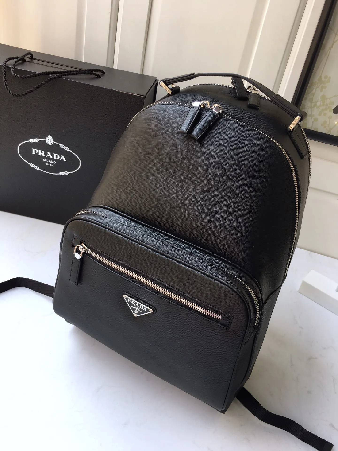 💰2360🎉Exclusive debut🎉Latest backpack 2VZ032👏👏Original item👍👍Made of imported Saffiano leather material, metal hardware accessories, two strap-type leather straps, one leather handle, back pocket, and can be inserted into the trolley case 😘😘With a two-way zipper, two front zipper pockets, the main compartment is equipped with a two-way zipper, a metal logo plate, two inner pockets, one of which has a zipper and an inner logo plate. This backpack has a simple line design and looks elegant and elegant👍👍Length 27xH 39.5 x bottom 16cm 👏👏👏💰💰💰