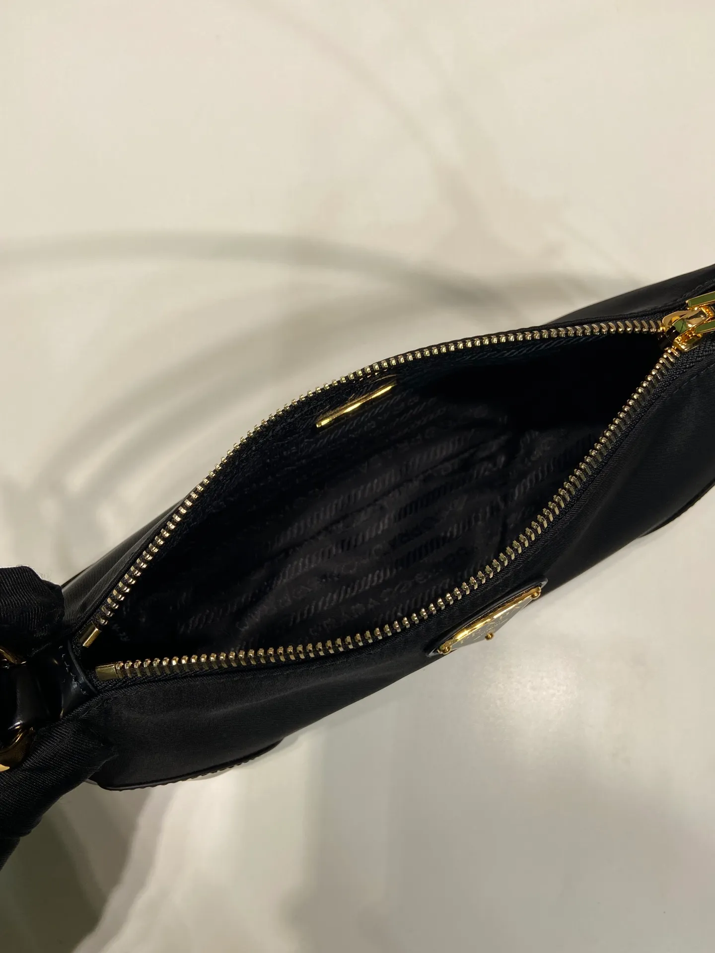 💰860🎉New armpit bag🎉1BC201/2002 model🎉🎉 This elegant and simple Re-Edition 2002 shoulder bag is made of innovative Re-Nylon regenerated nylon fabric and decorated with glossy leather details. Incorporating P-style and versatile design elements, it is equipped with adjustable shoulder straps, metal hardware and a detachable key ring. The enameled triangular metal logo highlights the brand's classic character. Lightweight and practical, get it now🎉 Length 23.5x Height 10x Bottom 5cm🎉🎉🎉👏👏👏