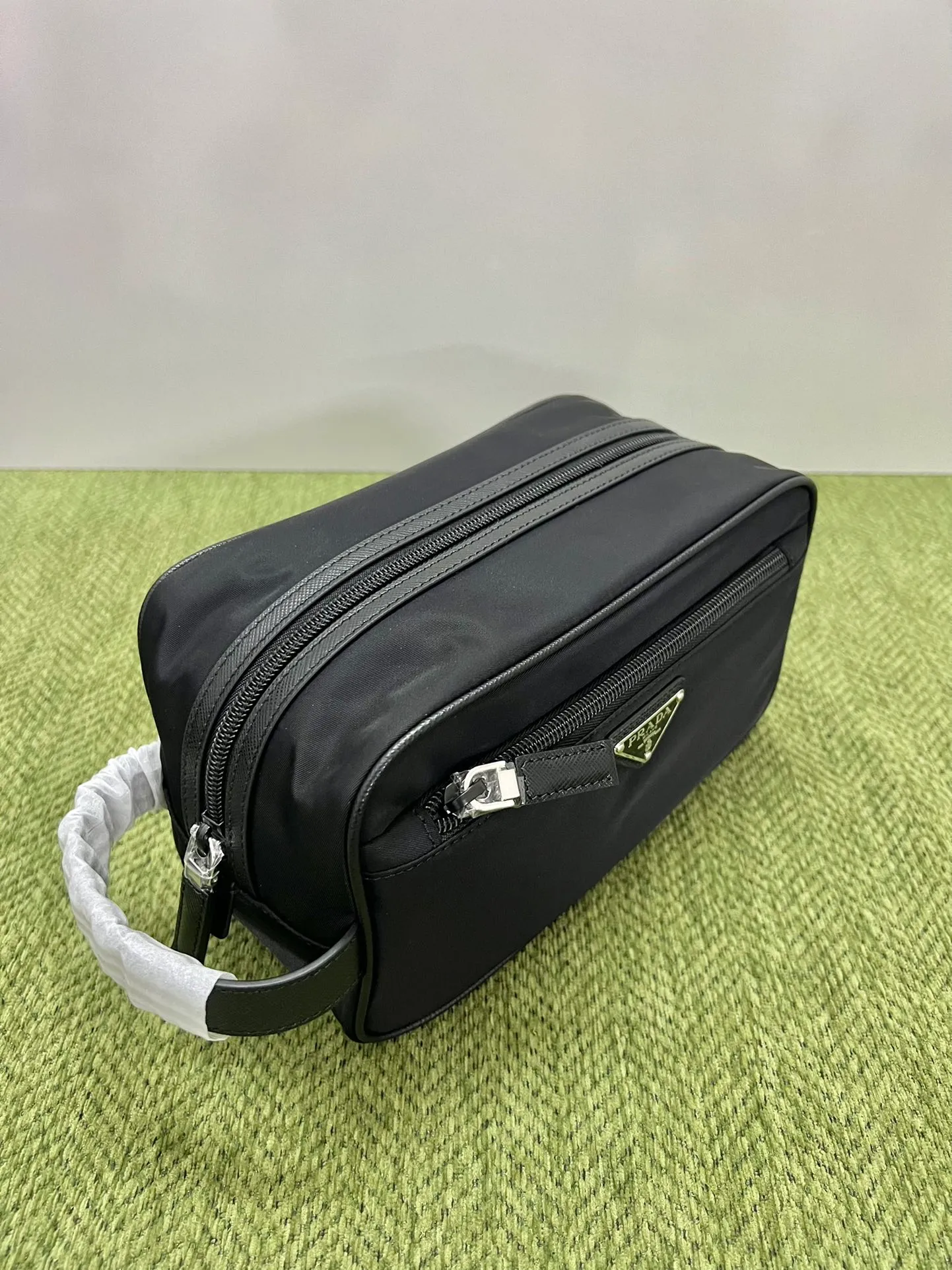 💰760, Prada toiletry bag/storage bag 2NA819, made of regenerated nylon and leather, with a zipper on the top and decorated with an enameled triangle logo and Saffiano leather details. This leather is made of imported original leather, leather handles, zipper closure, two external zippered pockets, and internal zippered pockets! Stylish and practical. Size: 22X12.5X11cm