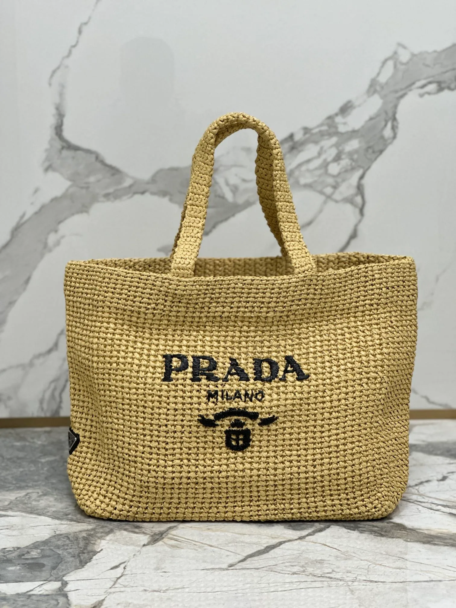 💰1900🌟Woven Tote Bag (Large Size) This tote bag is made of lightweight natural raffia fiber that is full of summer style. The soft deconstructed design gives the bag a unique modern charm. The iconic Prada lettering logo embroidery on the front subtly embellishes the silhouette. The striped pattern adds a contrasting element. So summery! Very versatile for everyday use. Size: length 40cm×height 34×width 15cm Style number: 1BG392
