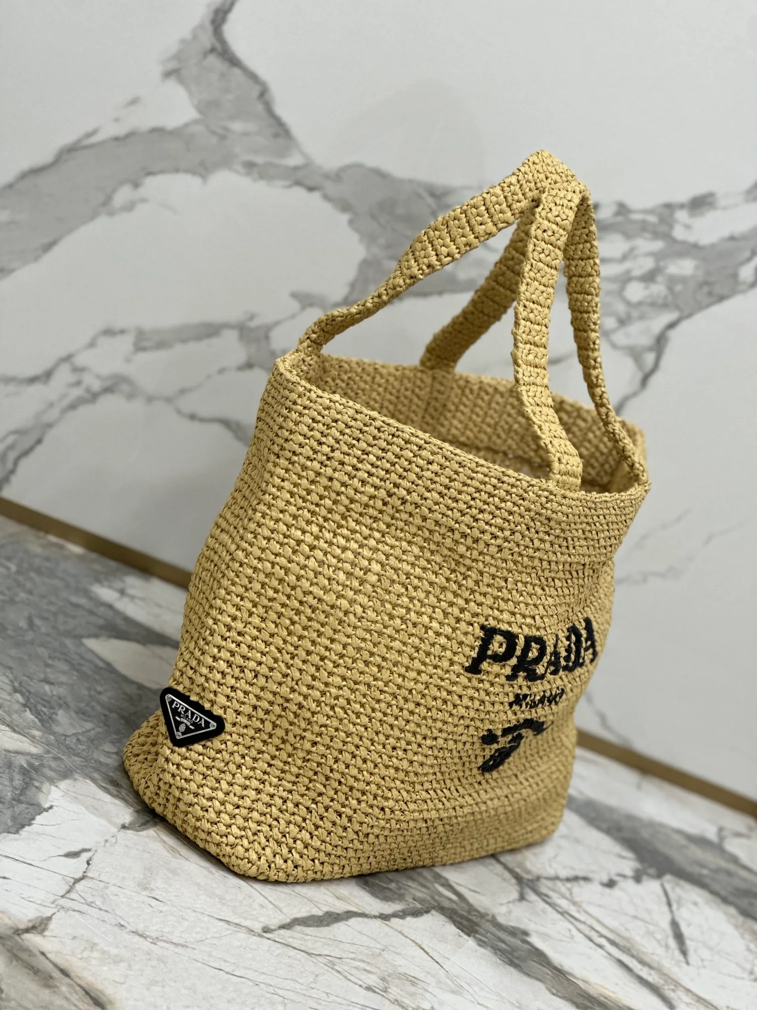 💰1900🌟Woven Tote Bag (Large Size) This tote bag is made of lightweight natural raffia fiber that is full of summer style. The soft deconstructed design gives the bag a unique modern charm. The iconic Prada lettering logo embroidery on the front subtly embellishes the silhouette. The striped pattern adds a contrasting element. So summery! Very versatile for everyday use. Size: length 40cm×height 34×width 15cm Style number: 1BG392