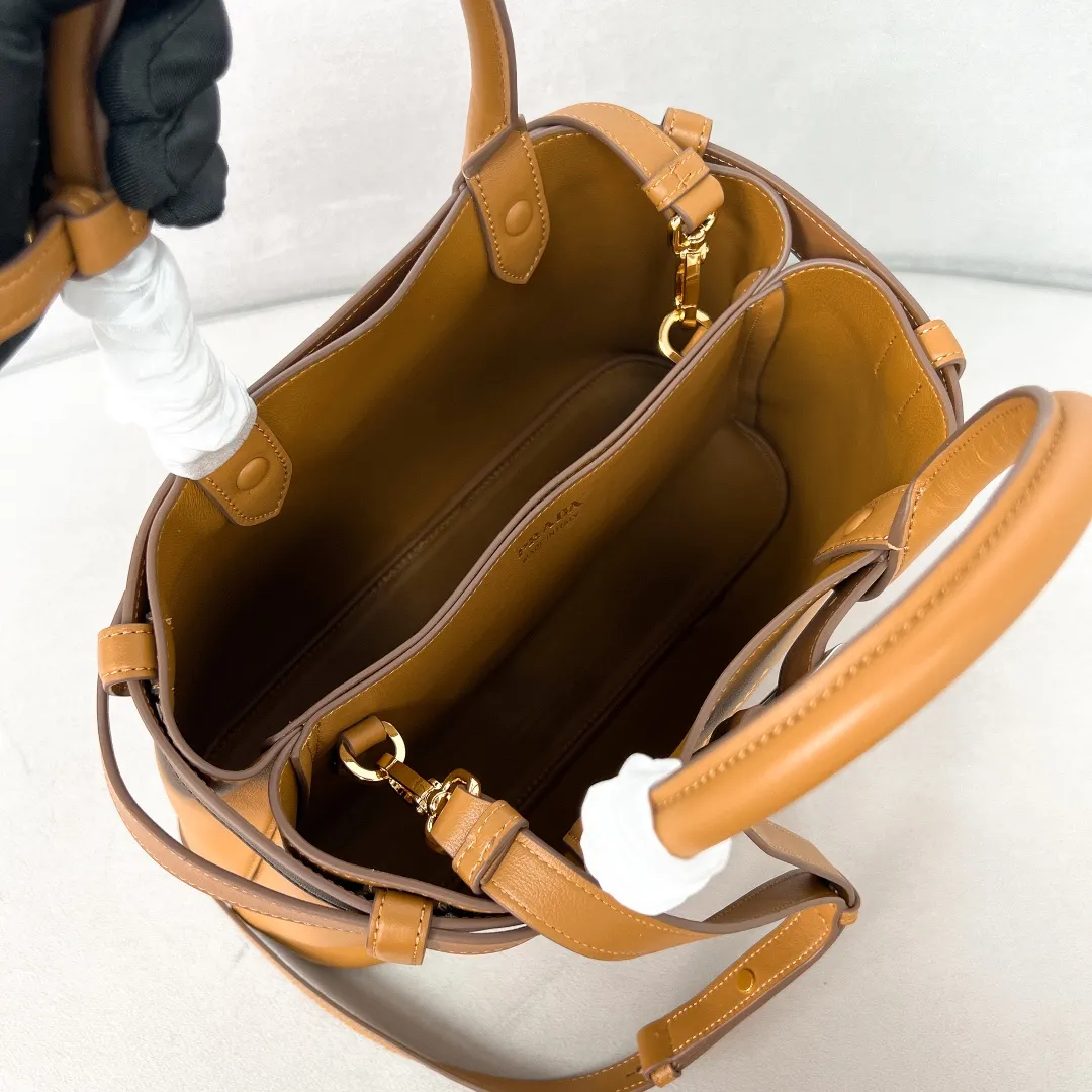 💰2040✨New product launch✨2024 early spring new medium wide drawstring leather handbag 1Ba434 Newly designed leather belt with unique style makes the bag infinitely dynamic. Made of chic and noble lambskin. Elegant and simple body design. Classic gold logo logo on the front. Equipped with adjustable shoulder straps, can be carried or worn cross-body. It has three compartments to meet exquisite storage needs. The perfect details are comparable to those of a brick cabinet. Super 5🌟 size: 32*23*11cm caramel color