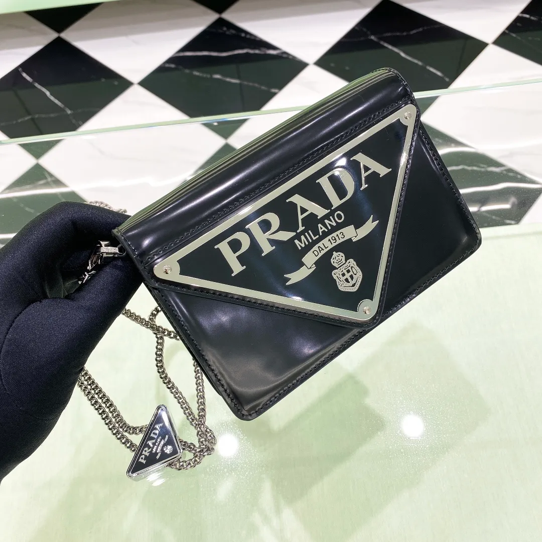 💰1320✨New product launch✨🌟New inverted triangle decorated glossy cowhide flip shoulder bag 1BH189 Novel and interesting inverted triangle metal chain with fashionable glossy cowhide Simple and elegant outline design and flip opening and closing, giving it a simple and fashionable style. It is simply great👏... The new favorite of fashion trendsetters The perfect details are comparable to those of brick cabinets Super 5🌟 Size:17*9.5*3.5cm black