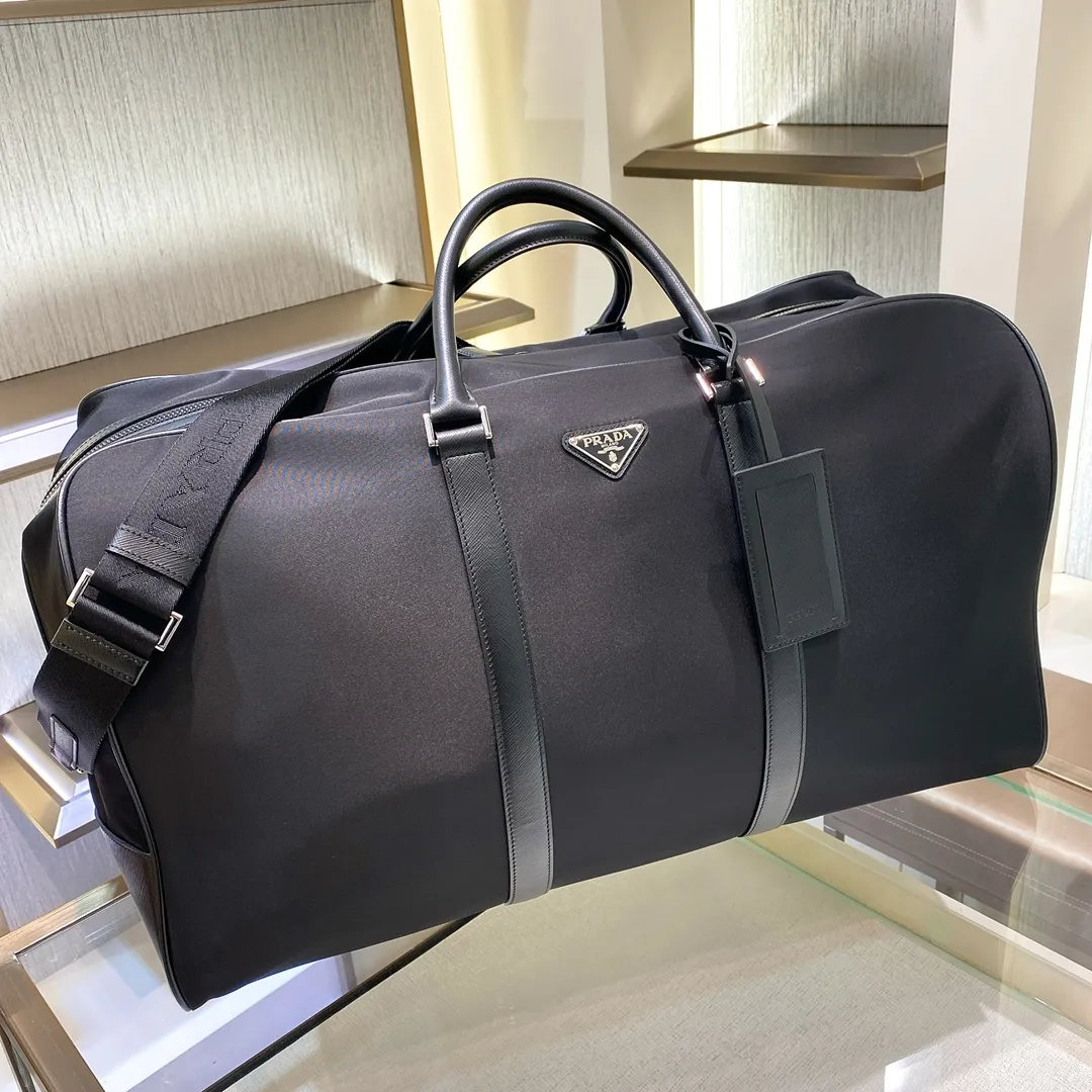 💰1580✨New product launch✨The latest nylon travel bag 2VC013 Imported parachute fabric + Saffiano cowhide Triangular enamel logo on the front Cross-grain cowhide handle Nylon is more lightweight Has a shoulder strap that can be detached at will A must-have for extra-large capacity travel Very convenient to carry on the plane✈ Size: 55*33*27cm Black