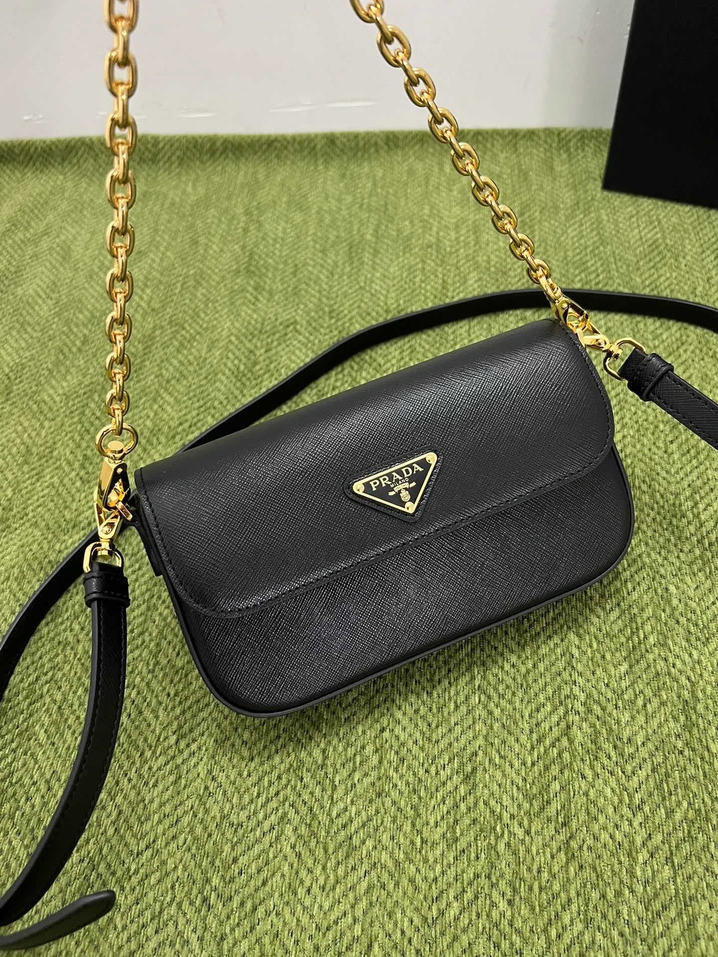 💰1300✨New mini chain shoulder bag✨1BD356 is made of Prada’s iconic waxed Saffiano leather, showing a very recognizable cross texture. Compact in shape, it comes with an adjustable shoulder strap and an elegant removable chain handle for versatile styling. Finished with gleaming metal hardware and an enameled metal triangle logo for a distinctive, timeless look. Detachable chain handle, detachable and adjustable Saffiano leather shoulder strap Metal hardware Flap with enamelled triangle metal logo Magnetic closure flap Nappa leather lining with patch pocket Height: 10.5cm Width: 20.5cm Length: 4cm