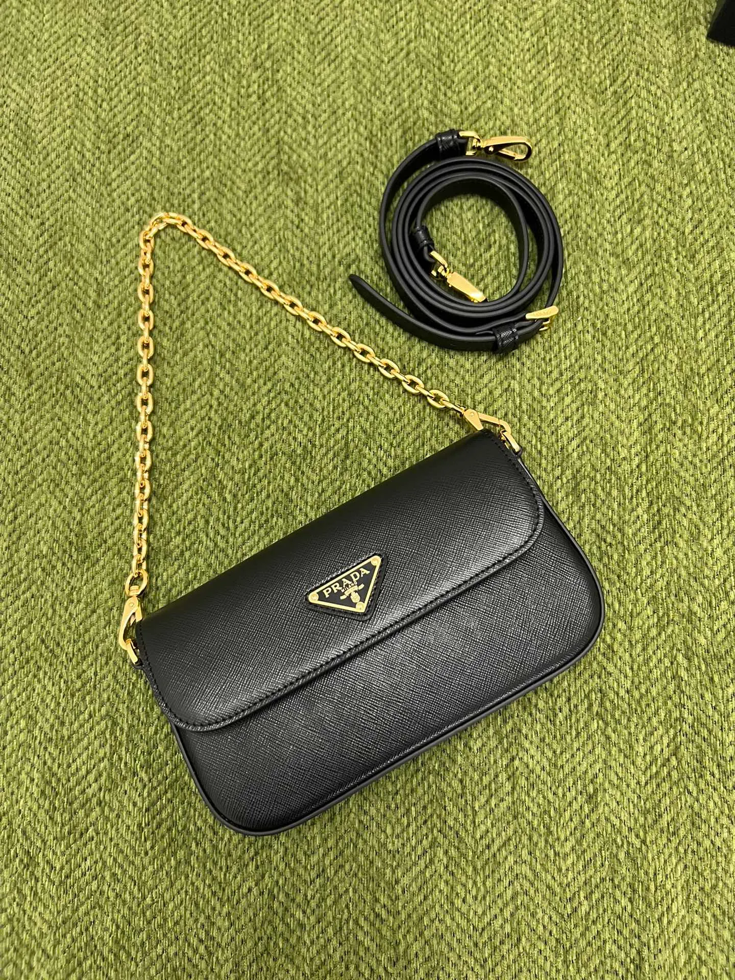 💰1300✨New mini chain shoulder bag✨1BD356 is made of Prada’s iconic waxed Saffiano leather, showing a very recognizable cross texture. Compact in shape, it comes with an adjustable shoulder strap and an elegant removable chain handle for versatile styling. Finished with gleaming metal hardware and an enameled metal triangle logo for a distinctive, timeless look. Detachable chain handle, detachable and adjustable Saffiano leather shoulder strap Metal hardware Flap with enamelled triangle metal logo Magnetic closure flap Nappa leather lining with patch pocket Height: 10.5cm Width: 20.5cm Length: 4cm