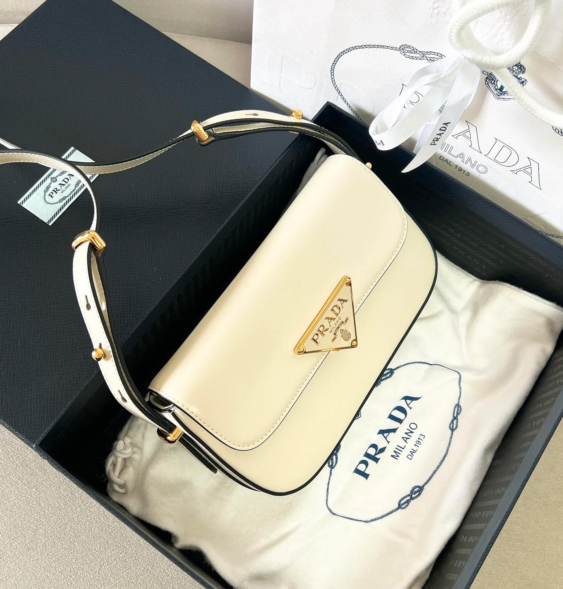 💰1440✨New product launch✨2023 new series shoulder bag 1BD339 is made of exquisite calfskin and is equipped with the iconic triangular logo decorative lock. The shoulder strap is adjustable and can be carried under the armpit or on one shoulder. The overall style of the bag is simple and the lines are elegant. Fashion and retro style are combined. The inner compartment capacity is also great. It is a new fashion trendsetter that combines retro fashion and practicality😘 Size 20.5*10.5*4 white