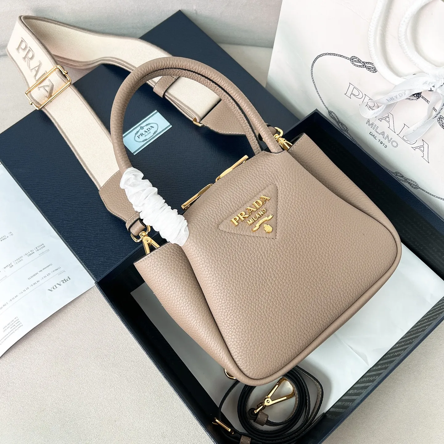 💰1760 ✨New product debut✨2025 new mini pebbled handbag/shoulder bag 1BA362 is made of soft textured pebbled calfskin. The bag has a rounded and soft silhouette. It is equipped with double handles and is decorated with a gold metal logo. Multifunctional detachable embroidered shoulder strap and leather shoulder strap. Elegant and outstanding style. Can be carried by hand, shoulder or crossbody. A handbag that perfectly blends classic heritage with contemporary trends. A must-have for fairies. Size 19.5*18*9cm