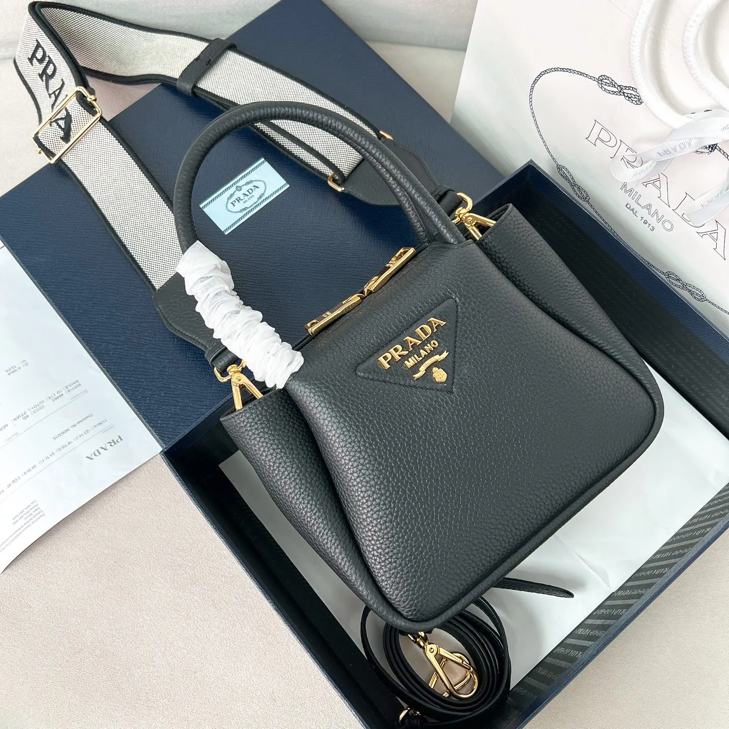 💰1760✨New product launch✨2025 new mini pebbled handbag/shoulder bag 1BA362 is made of soft textured pebbled calfskin. The bag has a rounded and soft silhouette. It is equipped with double handles and is decorated with a gold metal logo. Multifunctional detachable embroidered shoulder strap plus leather shoulder strap. Elegant and outstanding style. Can be carried in hand, on one shoulder or crossbody. A perfect fusion of classic heritage and contemporary trends. A must-have for fairies. Black. Size 19.5*18*9cm.