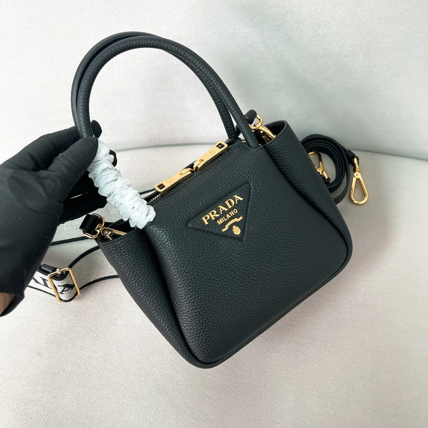 💰1760✨New product launch✨2025 new mini pebbled handbag/shoulder bag 1BA362 is made of soft textured pebbled calfskin. The bag has a rounded and soft silhouette. It is equipped with double handles and is decorated with a gold metal logo. Multifunctional detachable embroidered shoulder strap plus leather shoulder strap. Elegant and outstanding style. Can be carried in hand, on one shoulder or crossbody. A perfect fusion of classic heritage and contemporary trends. A must-have for fairies. Black. Size 19.5*18*9cm.