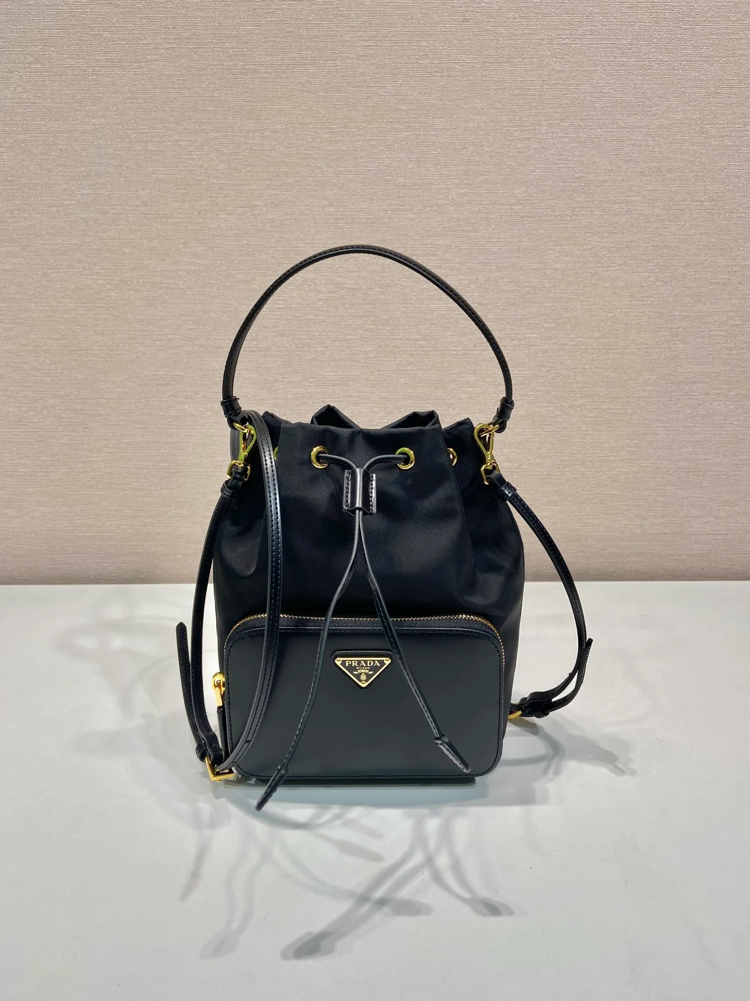 💰920🎉New bucket🎉1BH038 glossy/nylon fabric🎉🎉This casual and versatile bucket bag presents soft and smooth lines, highlighting modern style. Equipped with detachable handles and shoulder straps, it can be carried by hand or worn cross-body. It combines practical and innovative re-Nylon fabric (Re-Nylon), exquisite glossy leather details, and metal hardware. Featuring exterior zip pocket with enameled metal triangle logo. Another popular style that will never go out of style🎉🎉Babies; hurry up and get it🎉🎉 Length 17.5x Height 22.5x12cm